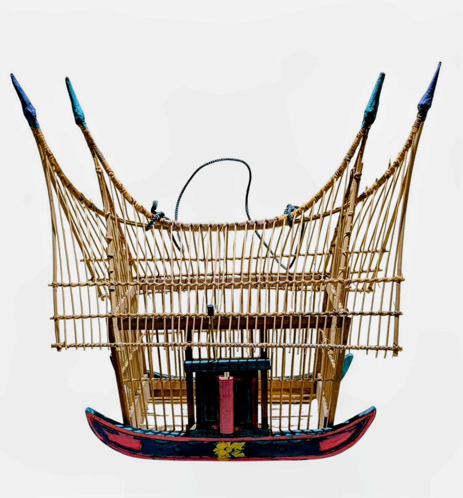 Asian spirit house style birdcage: crafted from bamboo and carved wood. Features a double-tiered roof with pointed finials at the ends. Carved wood ship form Polychrome decorated