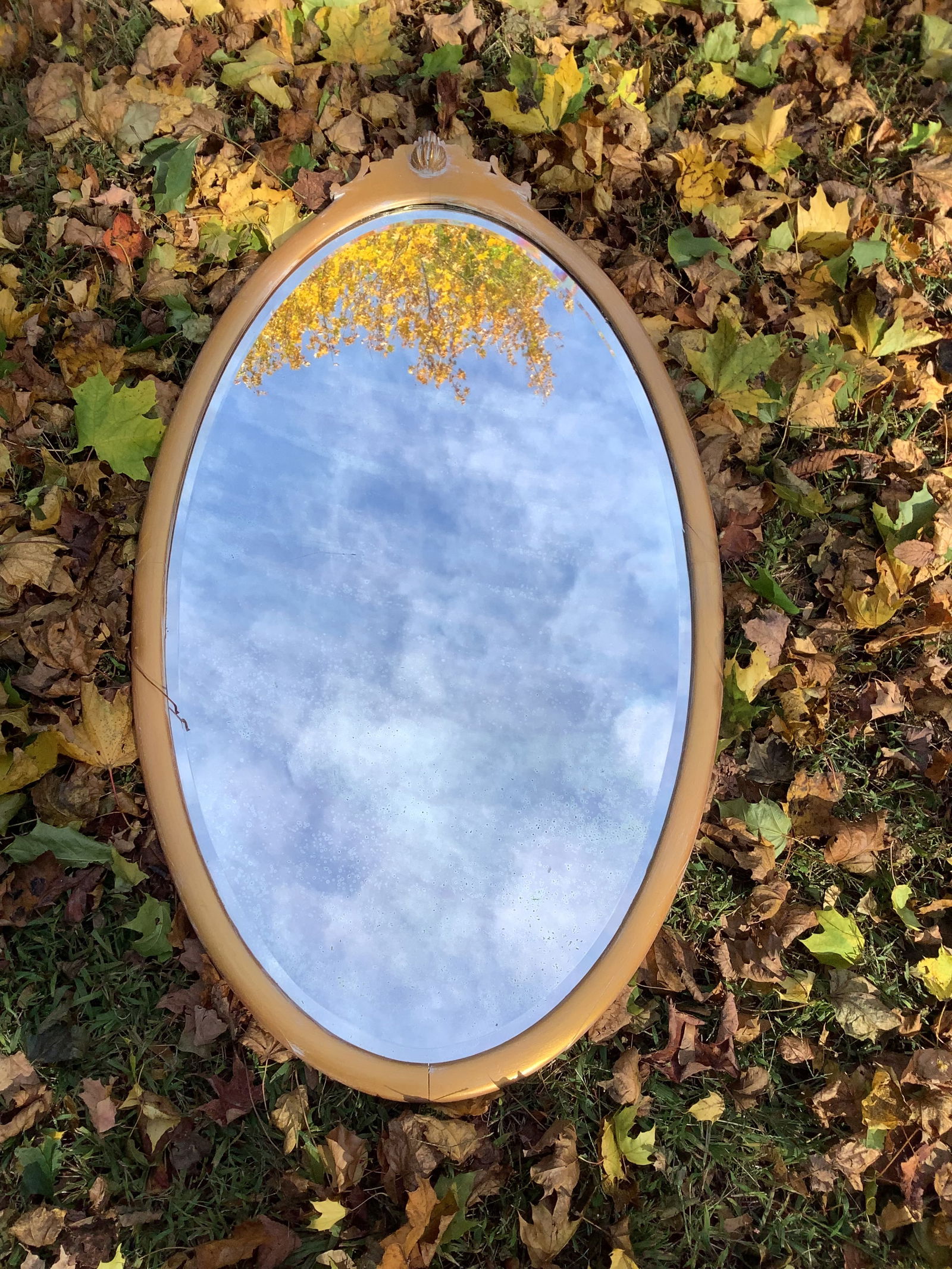 Vintage Hollywood Regency Oval Double Beveled Wall Mirror: Vintage Hollywood Regency style oval, double beveled wall mirror with a gold-toned frame. Mirror in good vintage condition, considering its age. Mirror measures 48” x 26”.