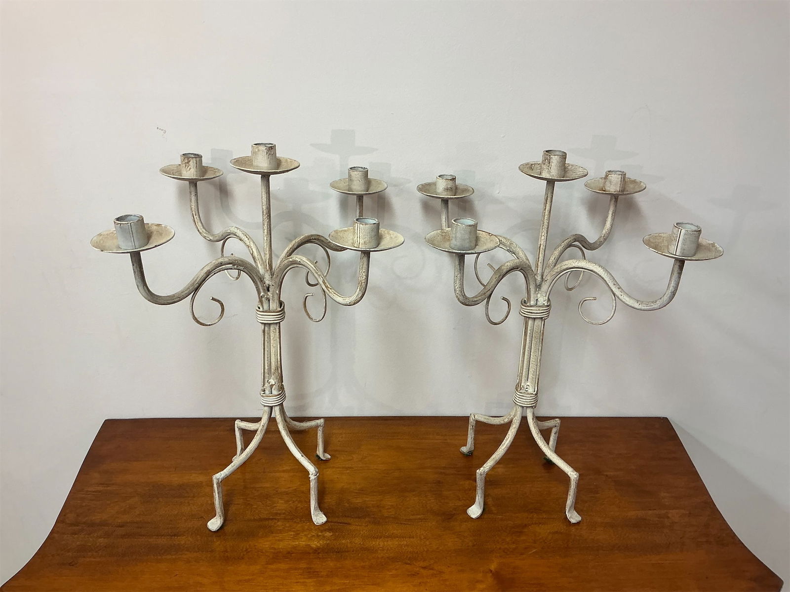 Pair of White Finish Metal 5 Arm Candelabras: This elegant pair of candelabras features a classic design, perfect for enhancing any decor. Crafted with a delicate intertwining framework, each candelabrum holds five candle cups, providing ample