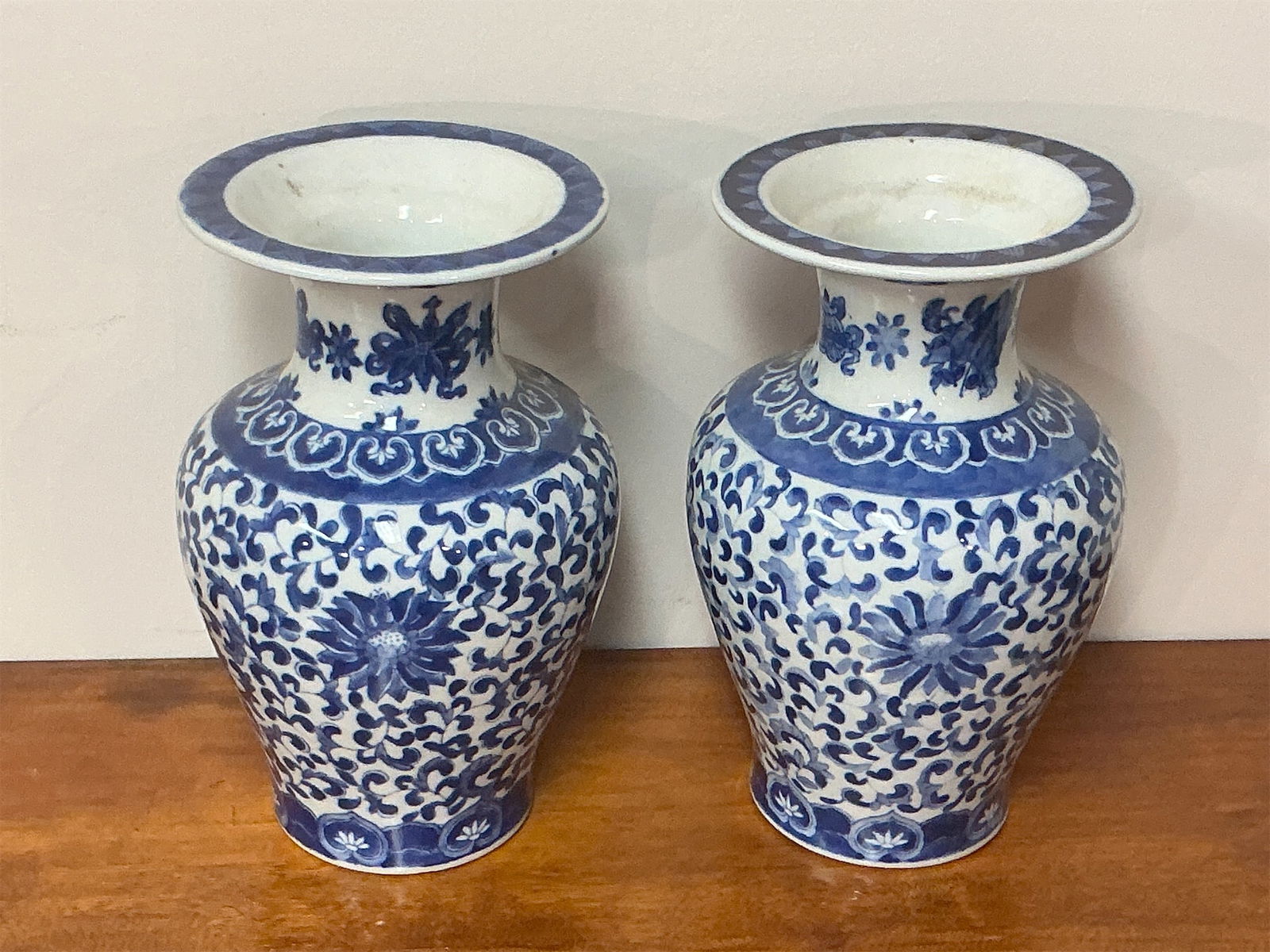 Asian Blue & White Porcelain Vases: Pair of Asian Blue & White Porcelain Vases featuring intricate floral patterns and elegant designs. Each vase showcases a classic shape with a flared rim and a bulbous body, adorned with detailed