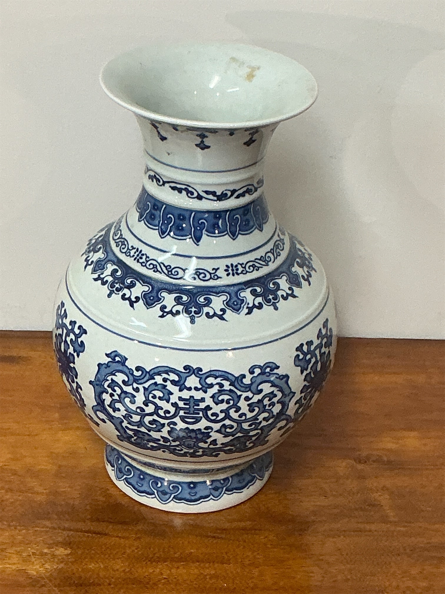 Asian blue and white porcelain vase: This exquisite Asian blue and white porcelain vase features a beautifully formed silhouette with intricate floral and geometric patterns adorning its surface. The vase showcases a traditional design