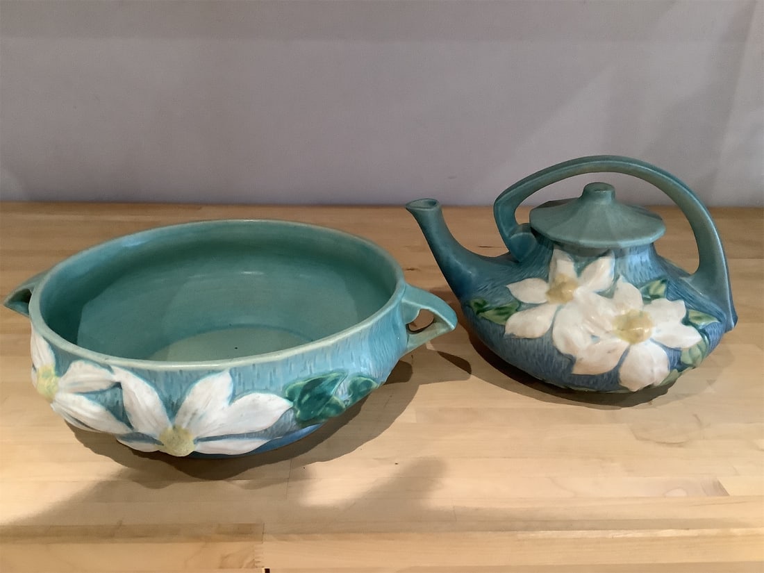 Roseville Potter: This exquisite Roseville Pottery set features a beautifully crafted teapot and matching bowl, showcasing the intricate floral designs that are characteristic of this celebrated American pottery. The