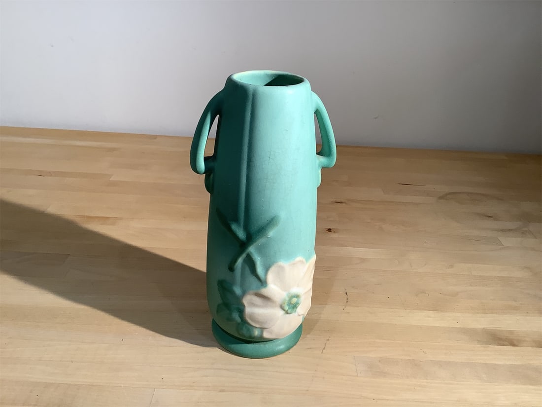 1930 s Weller Pottery: Beautifully crafted 1930s Weller Pottery vase showcases a charming design with delicate floral accents. Standing elegantly, the vase features a soft mint green glaze complemented by a subtle,