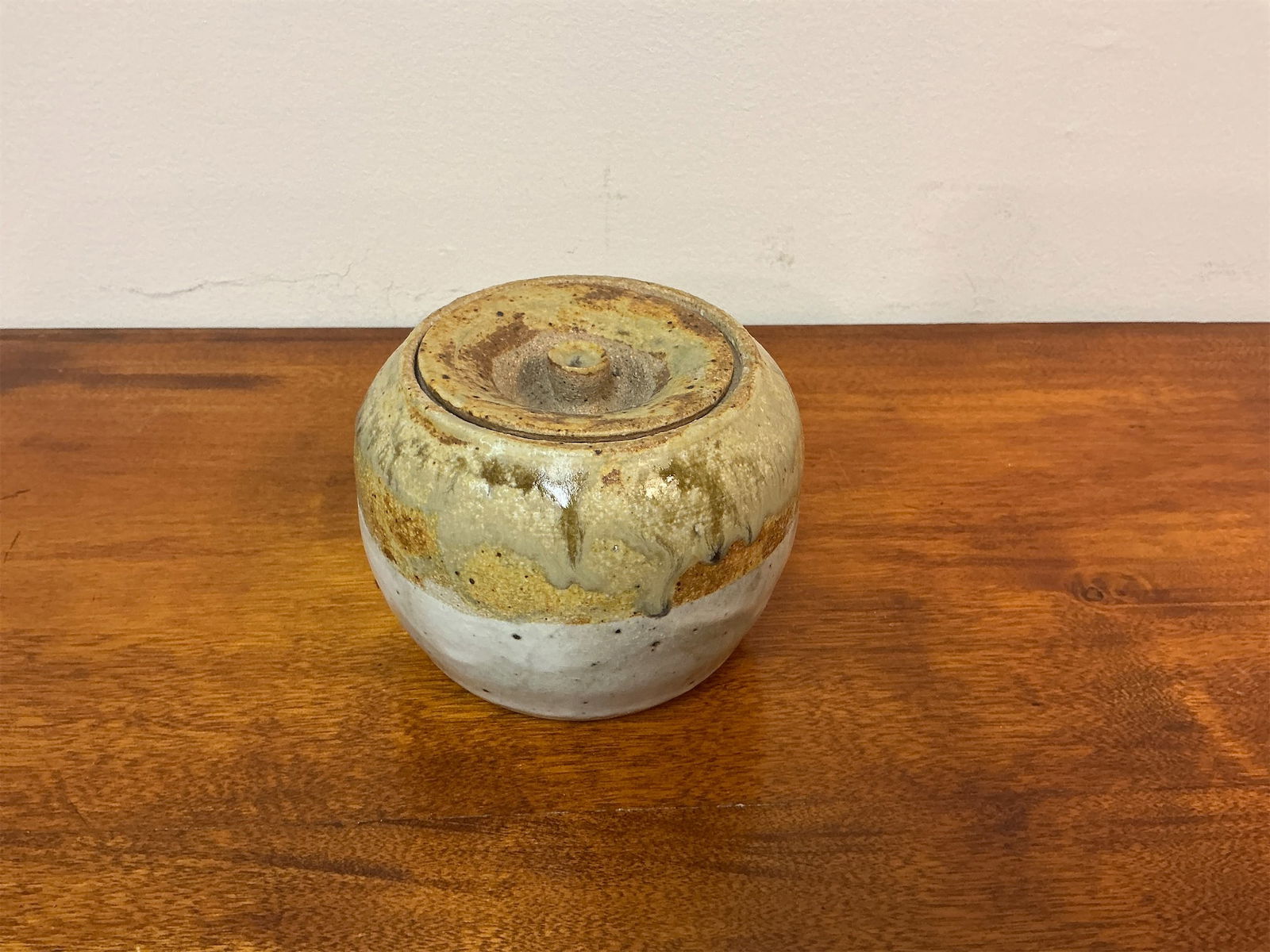 Vintage Studio Pottery Lidded Honey Pot: Studio pottery lidded honey pot features a unique design with a rustic glaze that showcases earthy tones of brown and white. The rounded shape is complemented by a perfectly fitting lid, adding charm