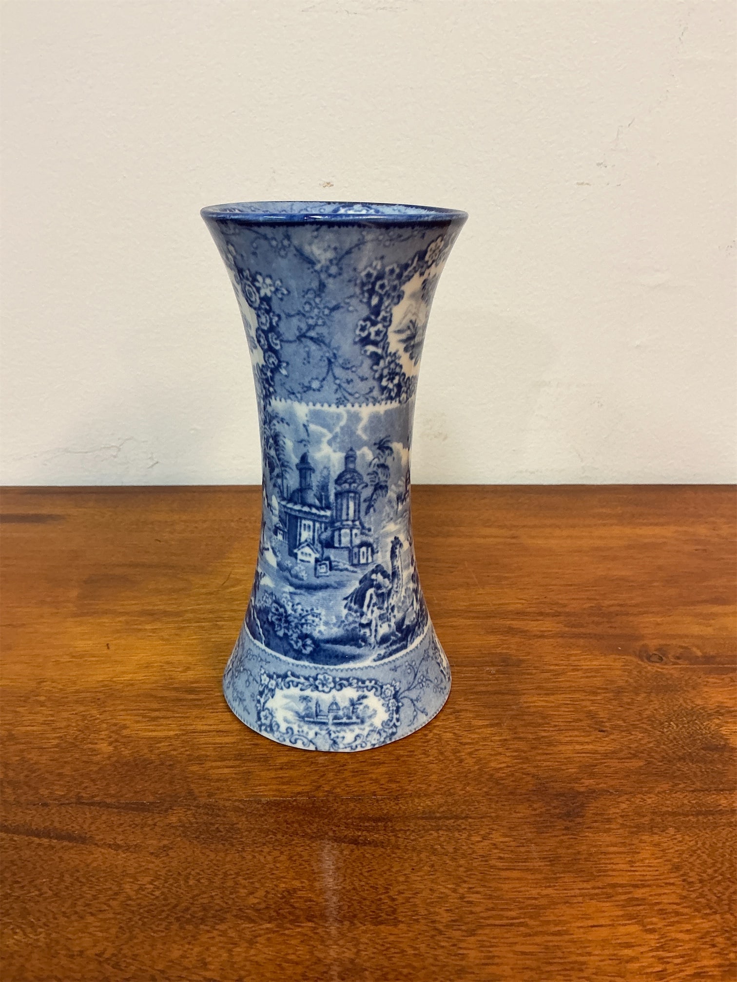 Antique H.M. & Co. Pottery Blue & White Vase: Vase from H. M & Company Ltd features a stunning blue and white transfer ware design. The vase showcases intricate scenes that evoke a sense of nostalgia and charm, reflecting classic craftsmanship.