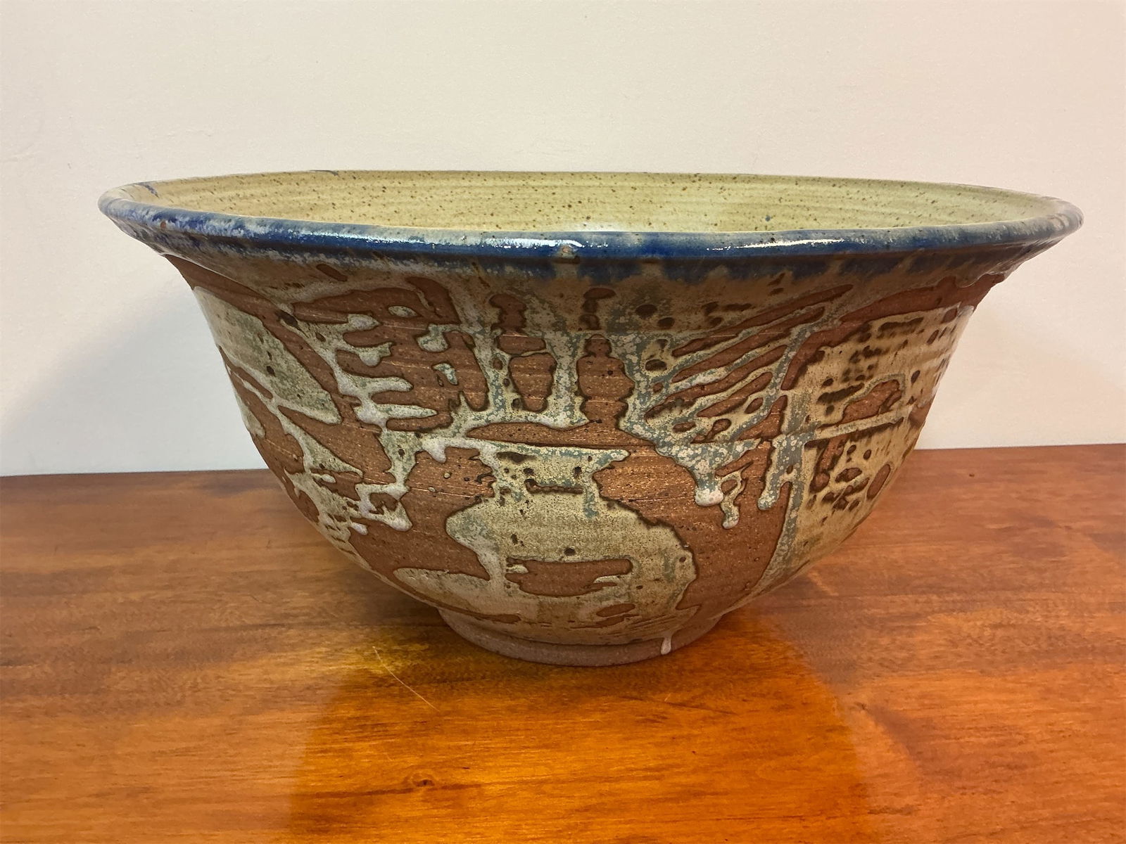 Signed Studio Pottery Stoneware Large Bowl: Large studio pottery stoneware bowl features a striking design with rich textures and a beautiful blend of earthy tones. The exterior showcases an intricate pattern that combines rustic browns and