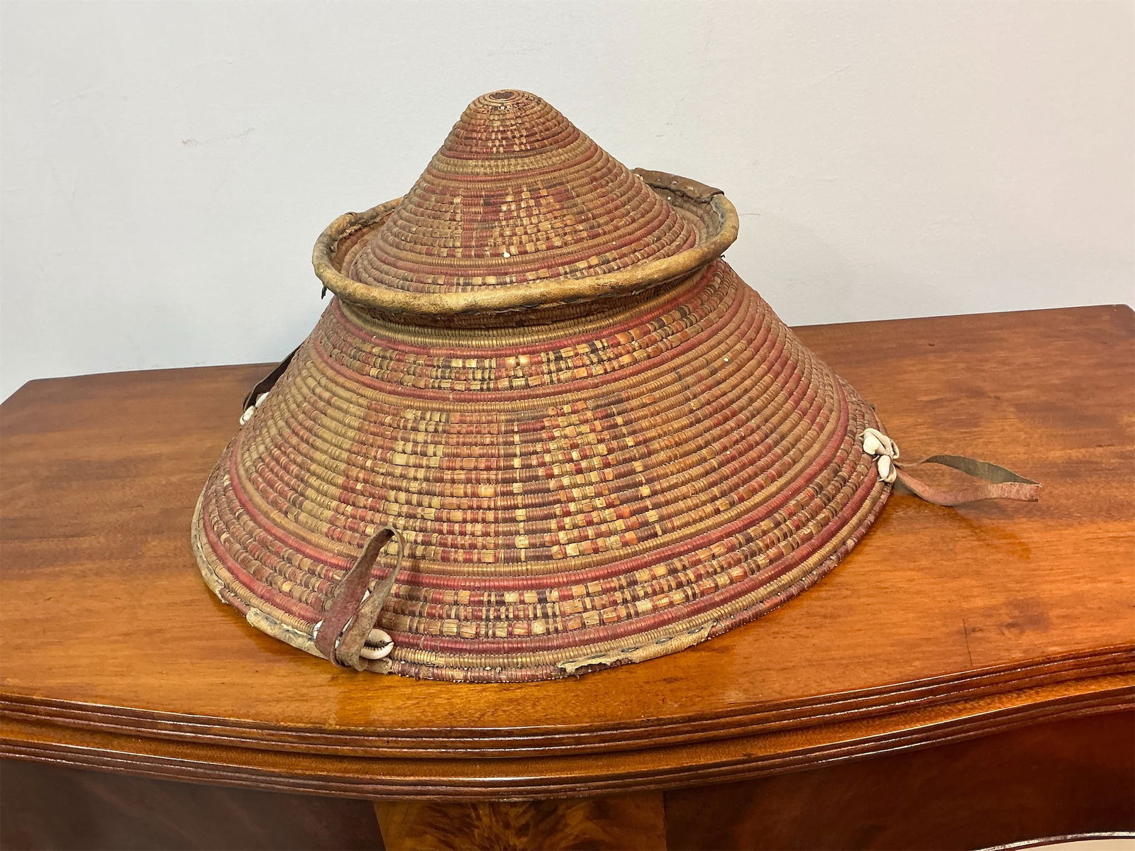 Vintage African Harari Leather-basket Ethiopia: Exceptional vintage African Harari leather-trimmed basket from Ethiopia showcases intricate craftsmanship and cultural significance. The basket features a traditional conical shape, beautifully woven