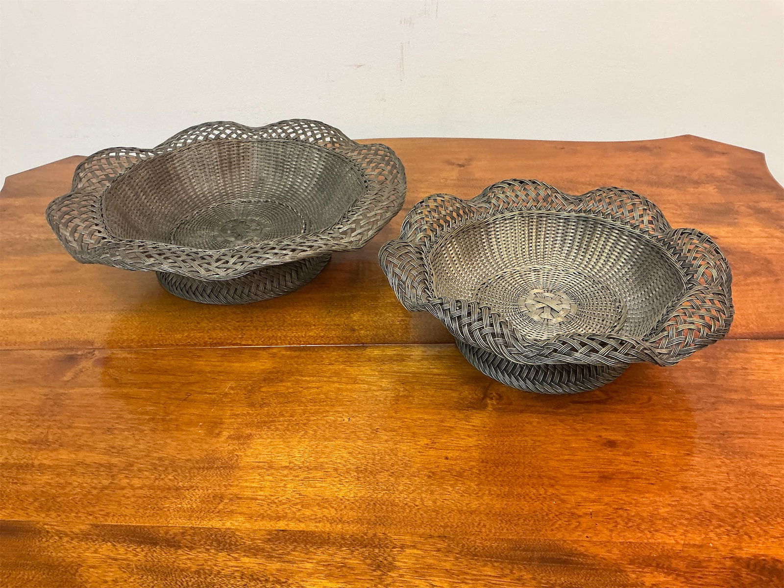 Set of 2 Silver Alloy Wire Woven Baskets: This set of two silver alloy wire woven baskets features a beautiful, intricate design perfect for enhancing any home decor. Each basket has a charming fluted edge, adding an elegant touch to its over