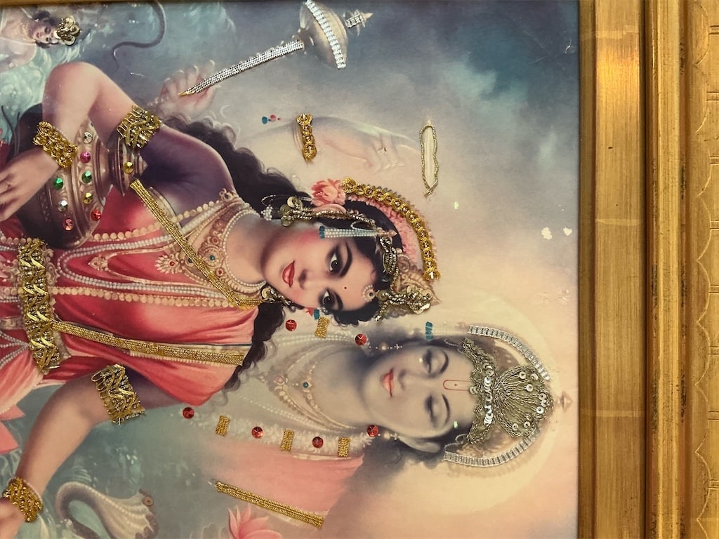 Framed Vintage-style devotional lithograph print depicting the Hindu deities Lakshey and Narayan: This vintage-style devotional lithograph print features a stunning depiction of the Hindu deities Lakshey and Narayan. The artwork showcases intricate details and vibrant colors, capturing the divine
