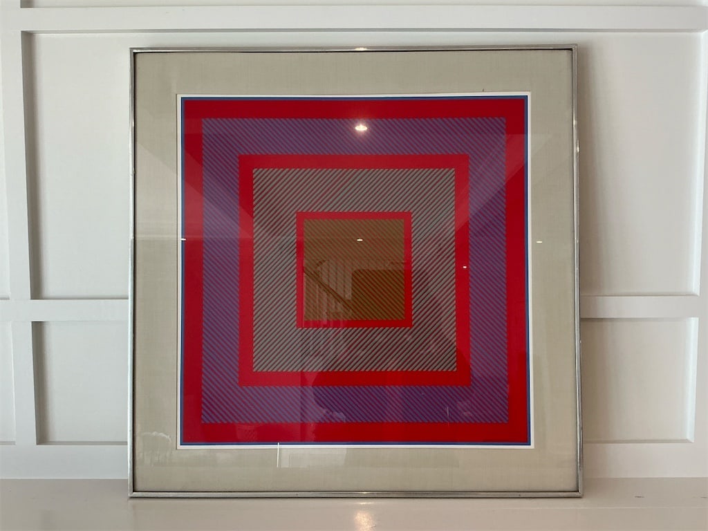 Framed Original Seritypien print on Aluminum Frame By: Richard Anuszkiewicz: Original Seritypien print on aluminum frame by Richard Anuszkiewicz. This captivating artwork features a striking display of geometric shapes in vibrant red, blue, and green hues, creating a bold