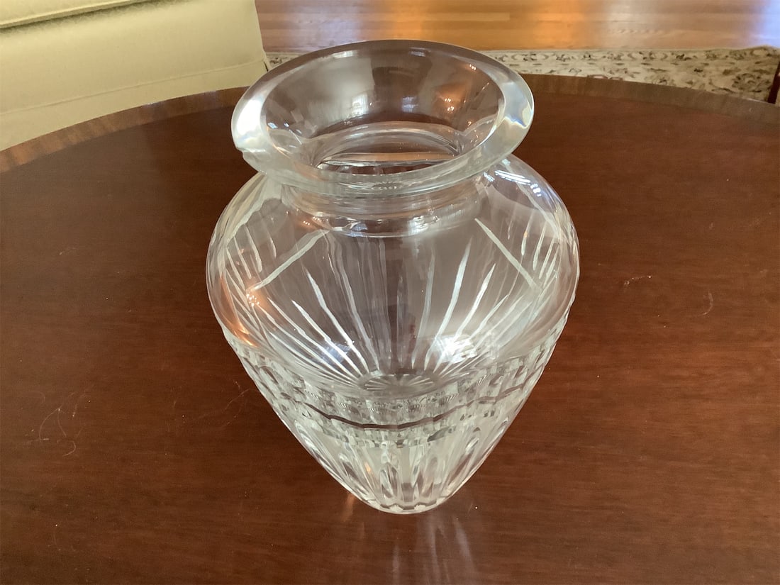 Crystal vase: This exquisite crystal vase features an elegant design with intricate cut patterns that reflect light beautifully. The vase has a classic shape, tapering gracefully from a wider mouth to a narrower