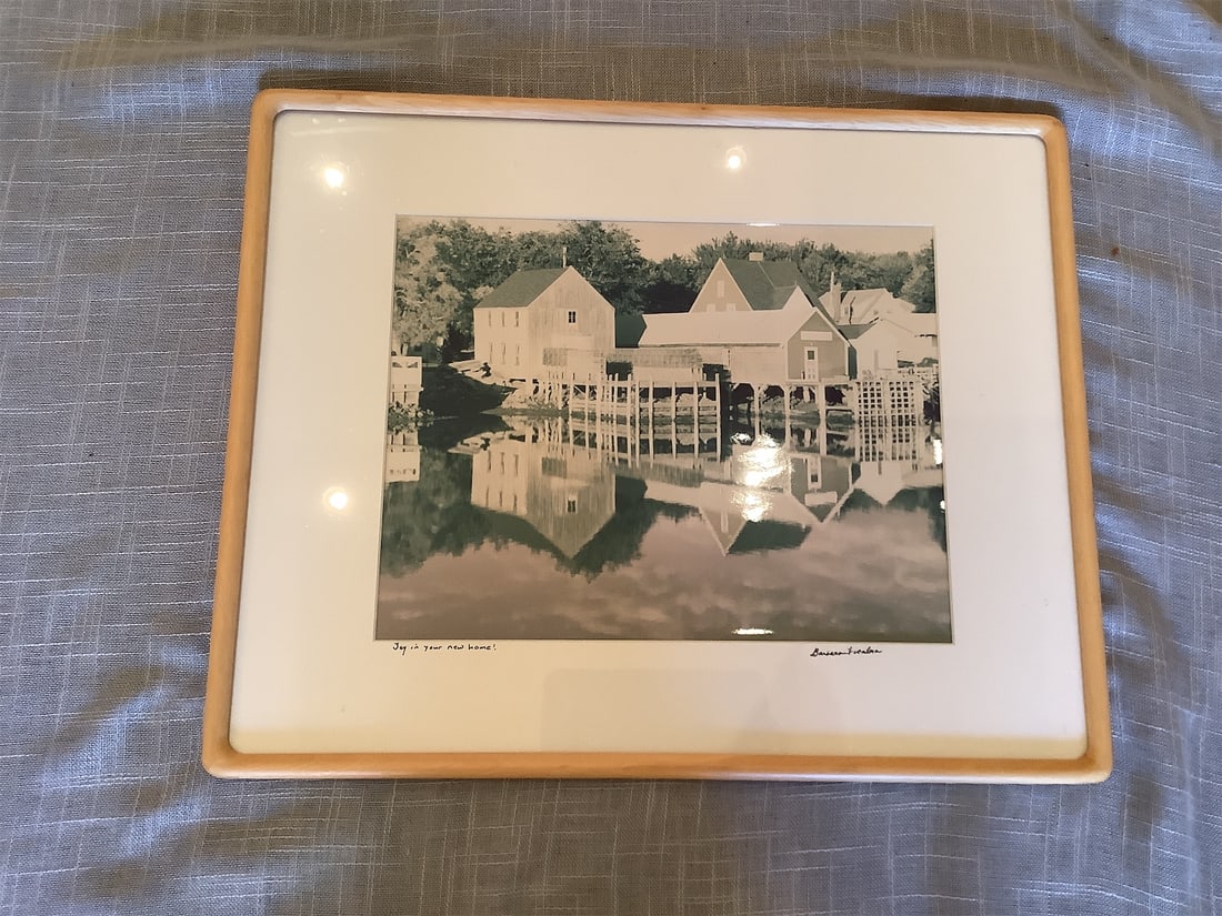 Framed Photograph - Westport CT On the Water: This elegant framed photograph features a serene waterfront scene, showcasing picturesque homes reflected in calm waters. The image captures a tranquil moment, enhanced by soft, muted tones. It is sig