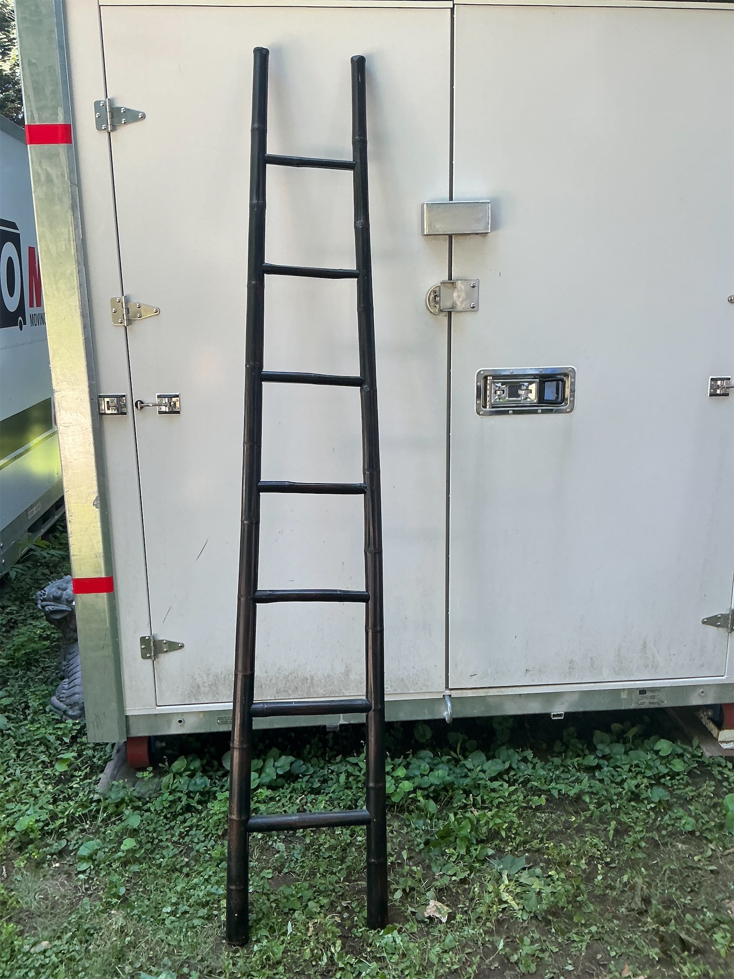 Bamboo ladder: This bamboo ladder features a sleek, dark finish that highlights its natural beauty and craftsmanship. Constructed from sturdy bamboo, it stands tall with a design that includes multiple rung levels