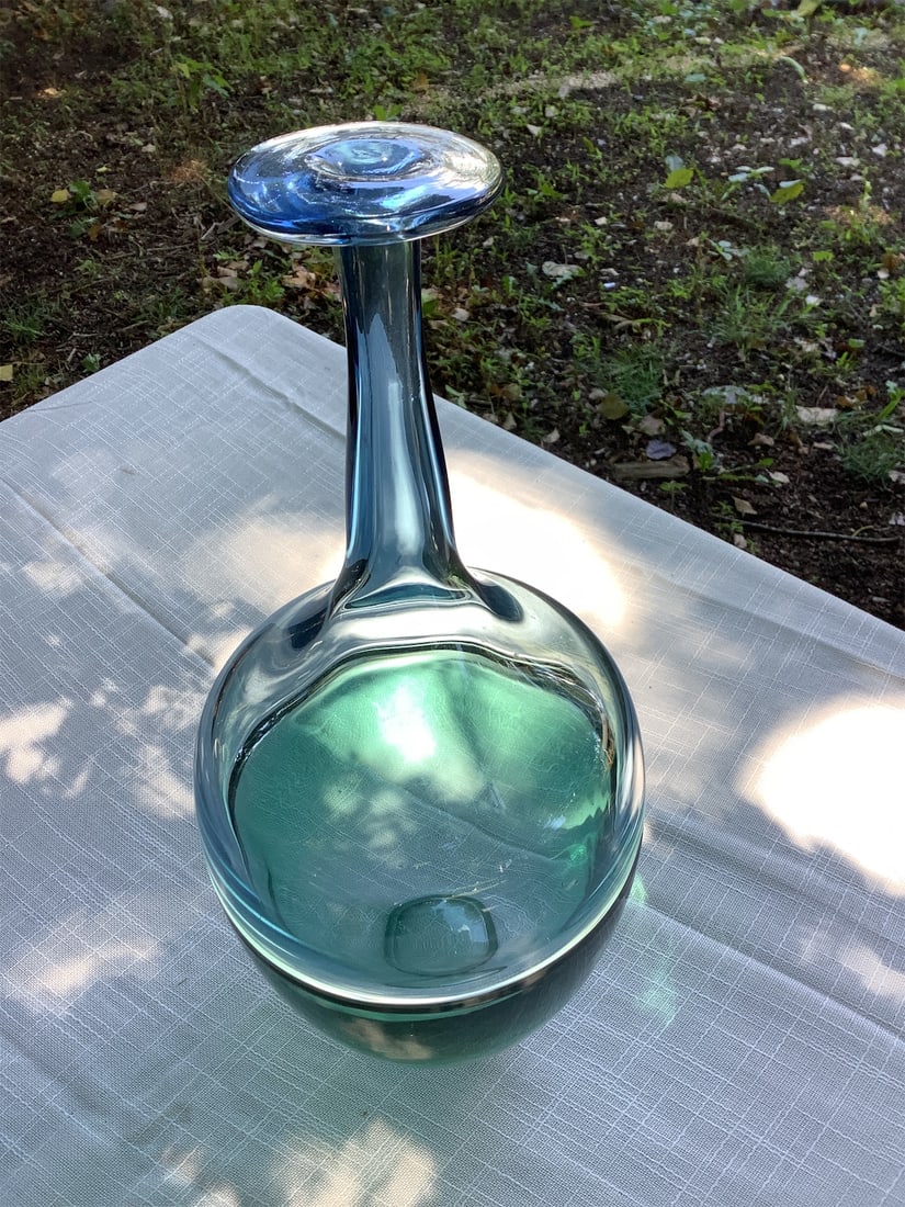 Vintage blown glass: This exquisite vintage blown glass piece showcases a distinctive design with a captivating blend of colors ranging from deep blue to serene aqua. Its graceful curves and elegant form create a