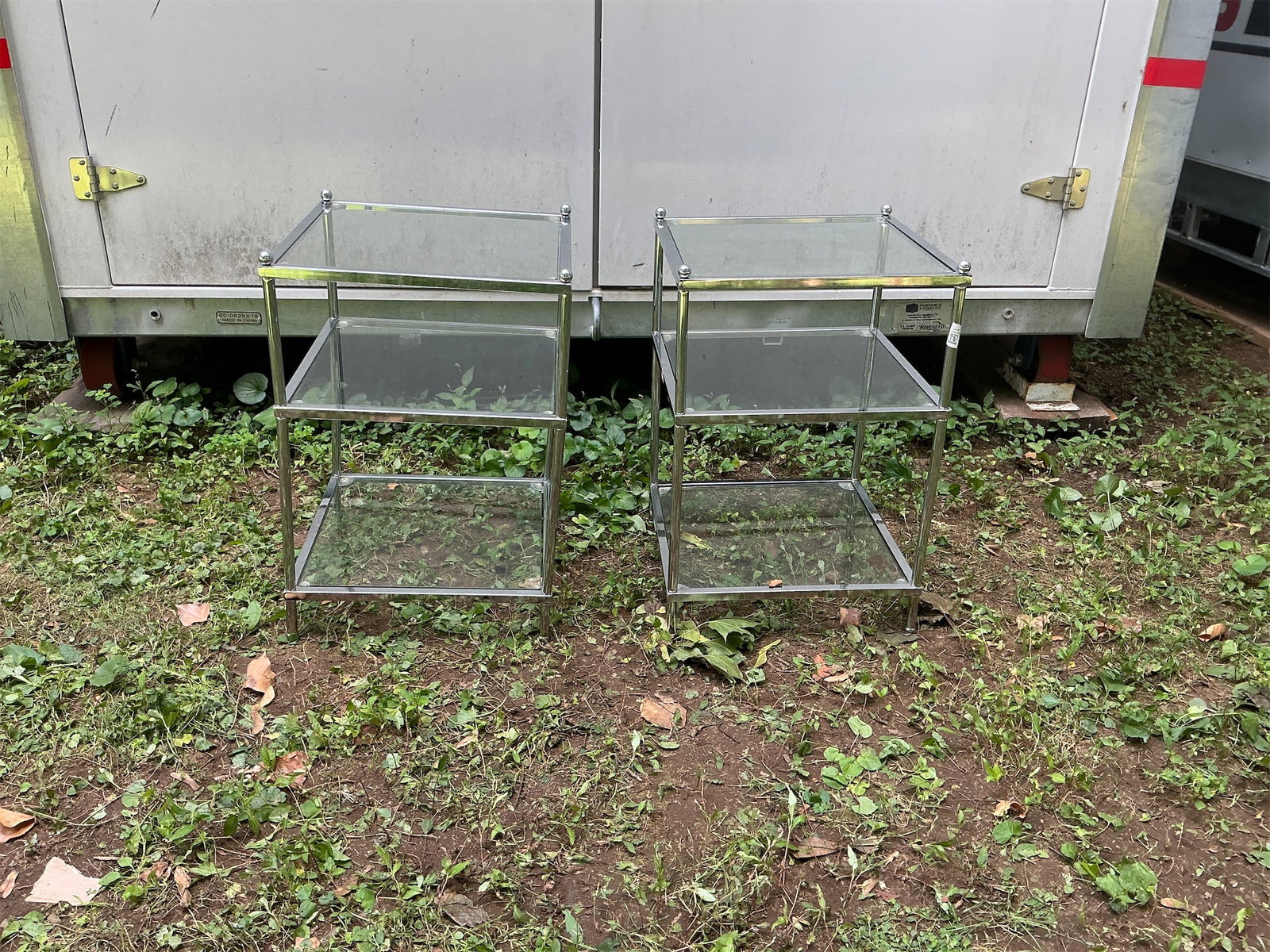 Pair of Sidetables. Glass & chrome: This listing features a pair of stylish glass side tables, perfect for enhancing any living space. Each table showcases a contemporary design with a sleek structure, combining sturdy metal frames