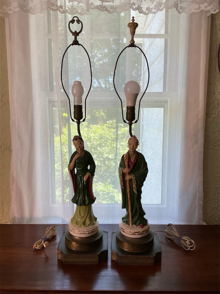 Vintage Mid Century Asian Figural Lamps: This exquisite pair of vintage Cinoisserie ceramic figural lamps showcases remarkable craftsmanship and intricate detailing. Each lamp is hand painted and features a beautifully designed figure in tra