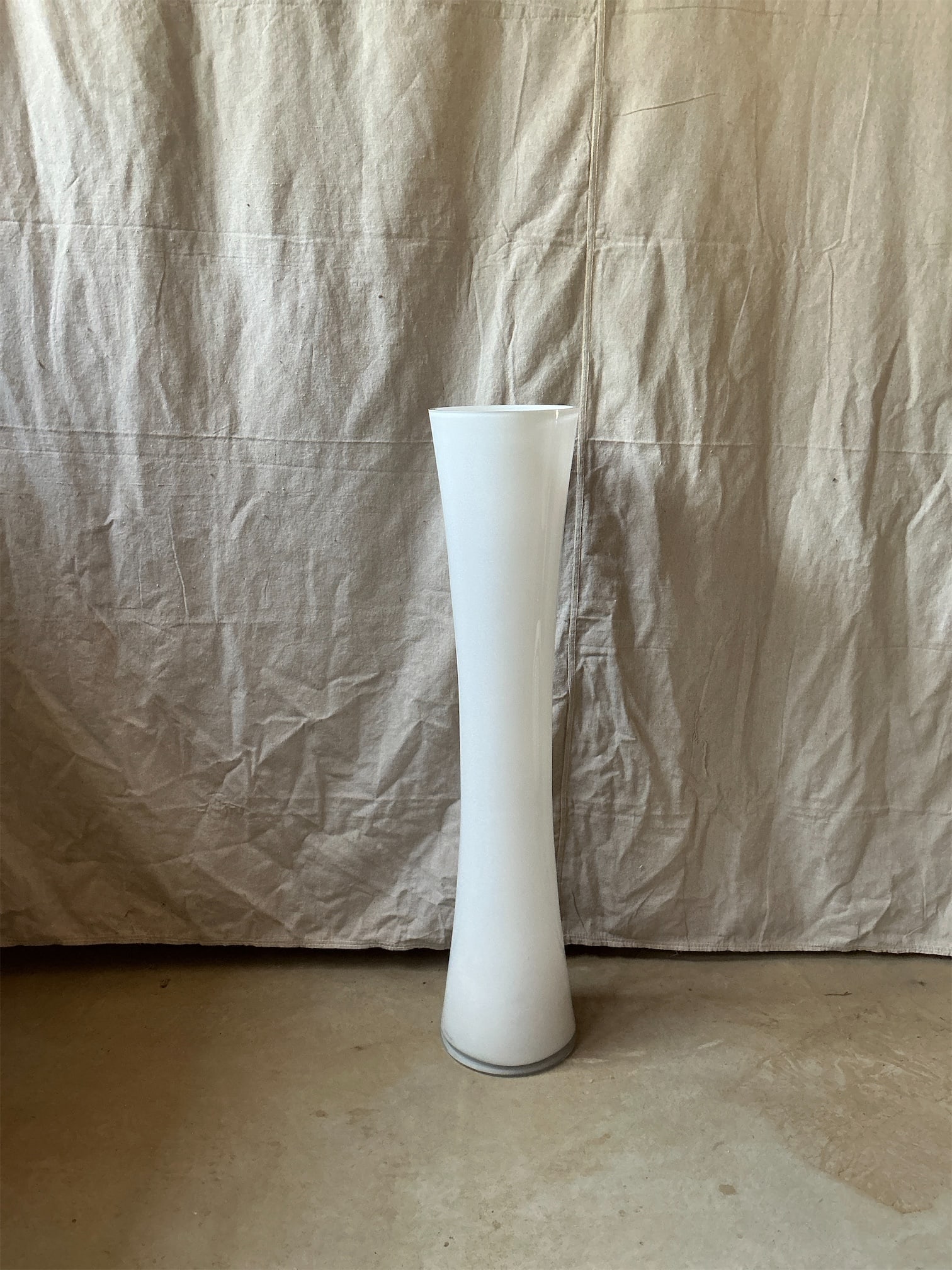 Handmade White Glass Vase: Elevate your space with this stunning handmade white vase, characterized by its elegant, contemporary shape. The vase features a tall and slender silhouette that gracefully flares at the top, making i