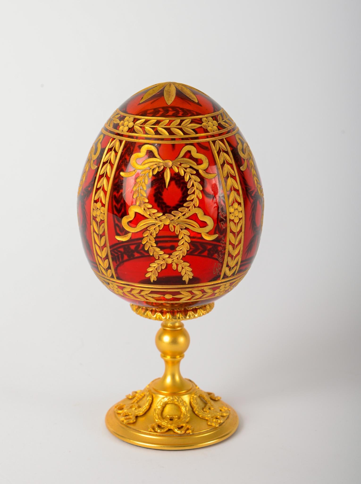 FABERGE RED GLASS EGG ON GILT STAND. (1 of 3)