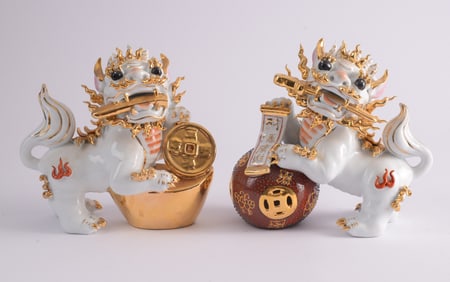 Pair of Elaborate White and Gold Porcelain Foo Dogs.
