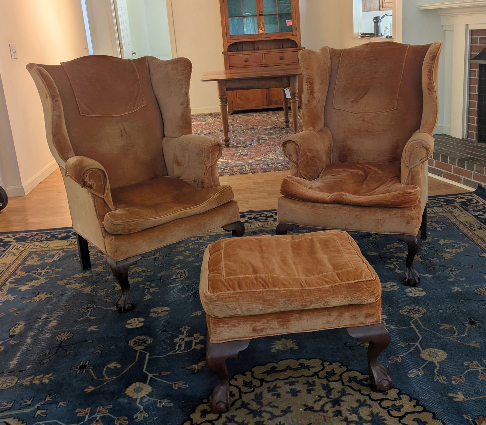 Two Wing Chairs and a Footstool.: Upholstery worn