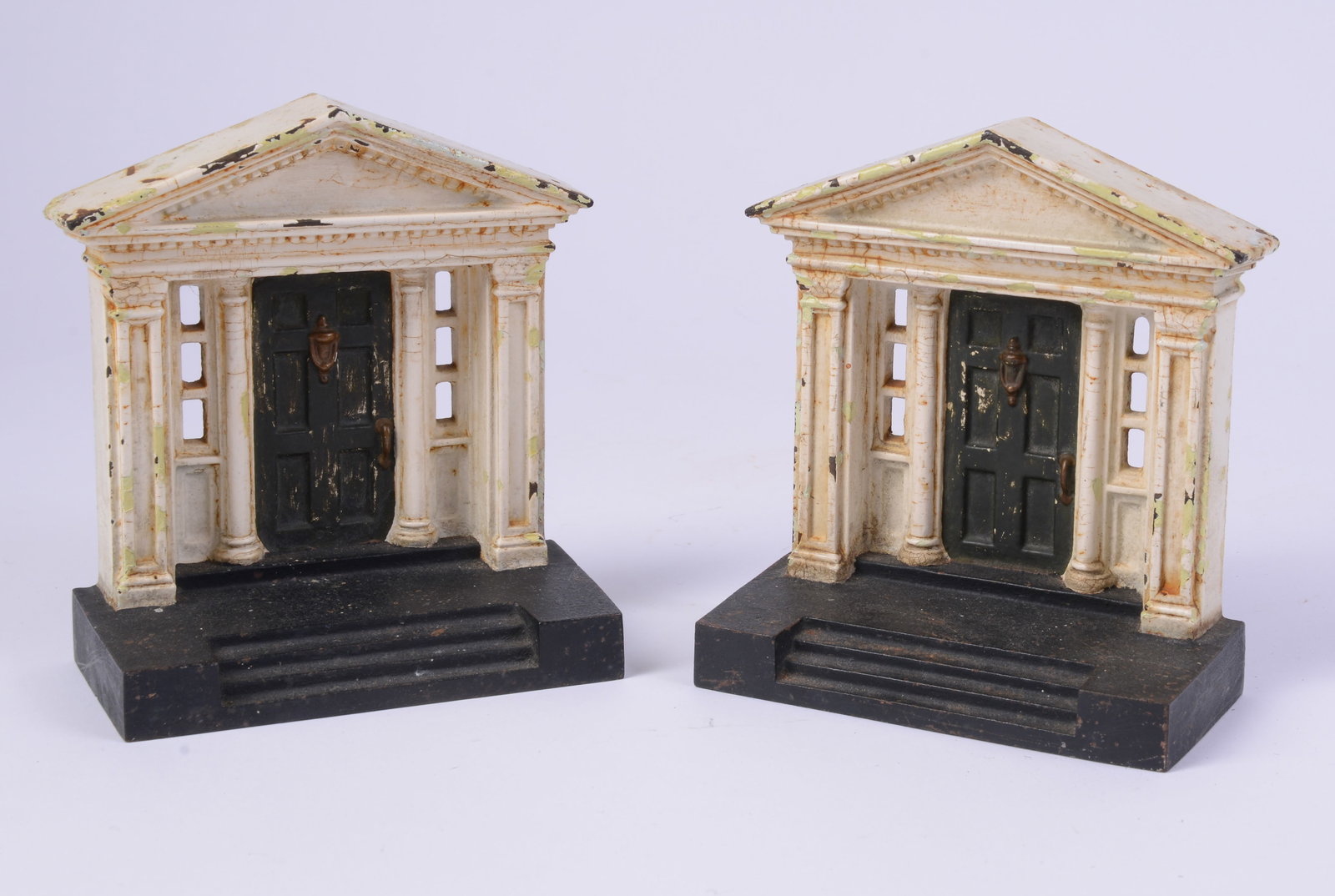 PAIR OF CAST IRON BOOKENDS.: Designed to look like the entry door to a house. Circa 1920s - 1940s. Height 5.25 inches, width 5 inches. Some paint loss.