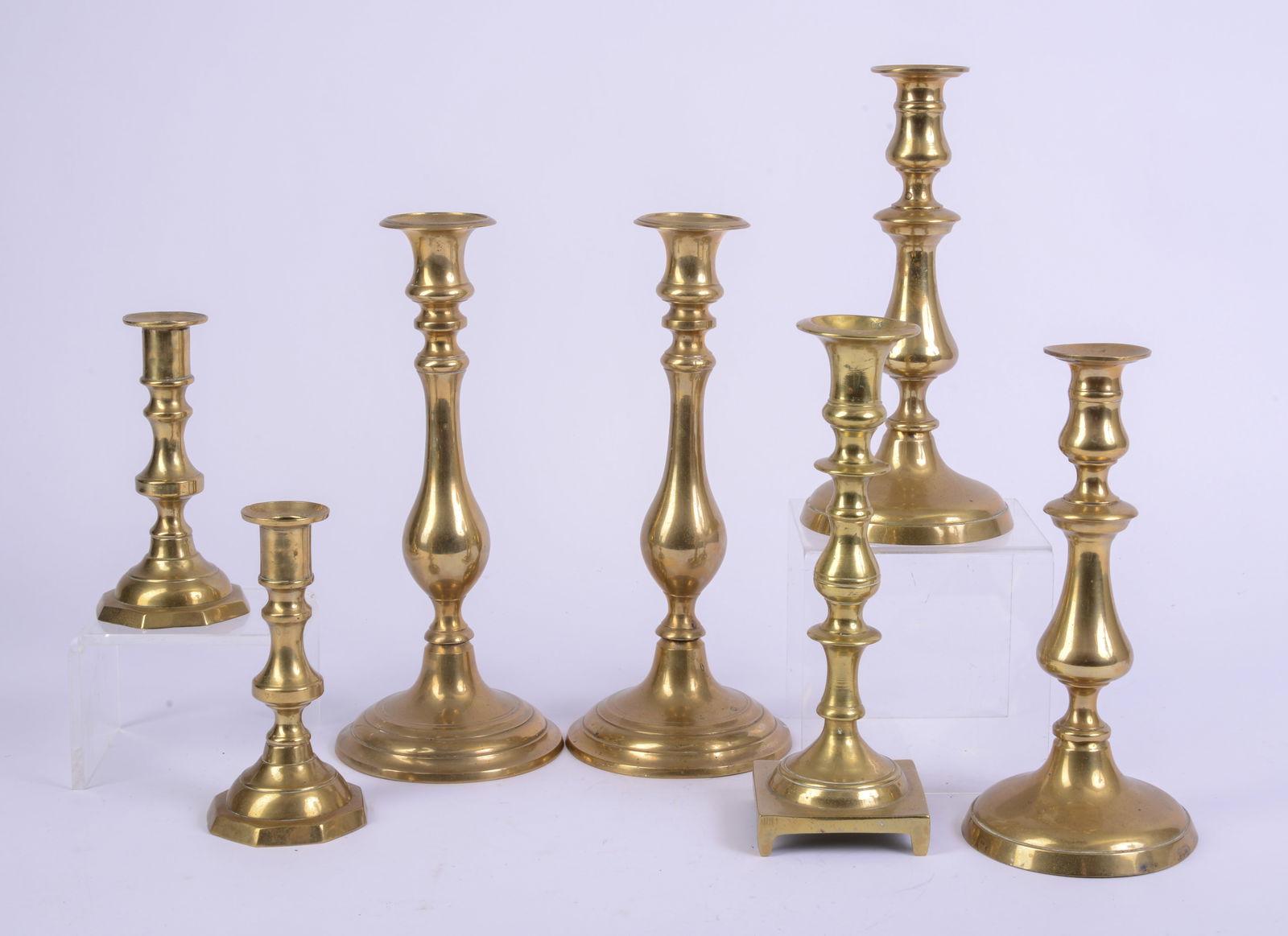Seven Brass Candlesticks.: Heights 6.25 to 11.25 inches.