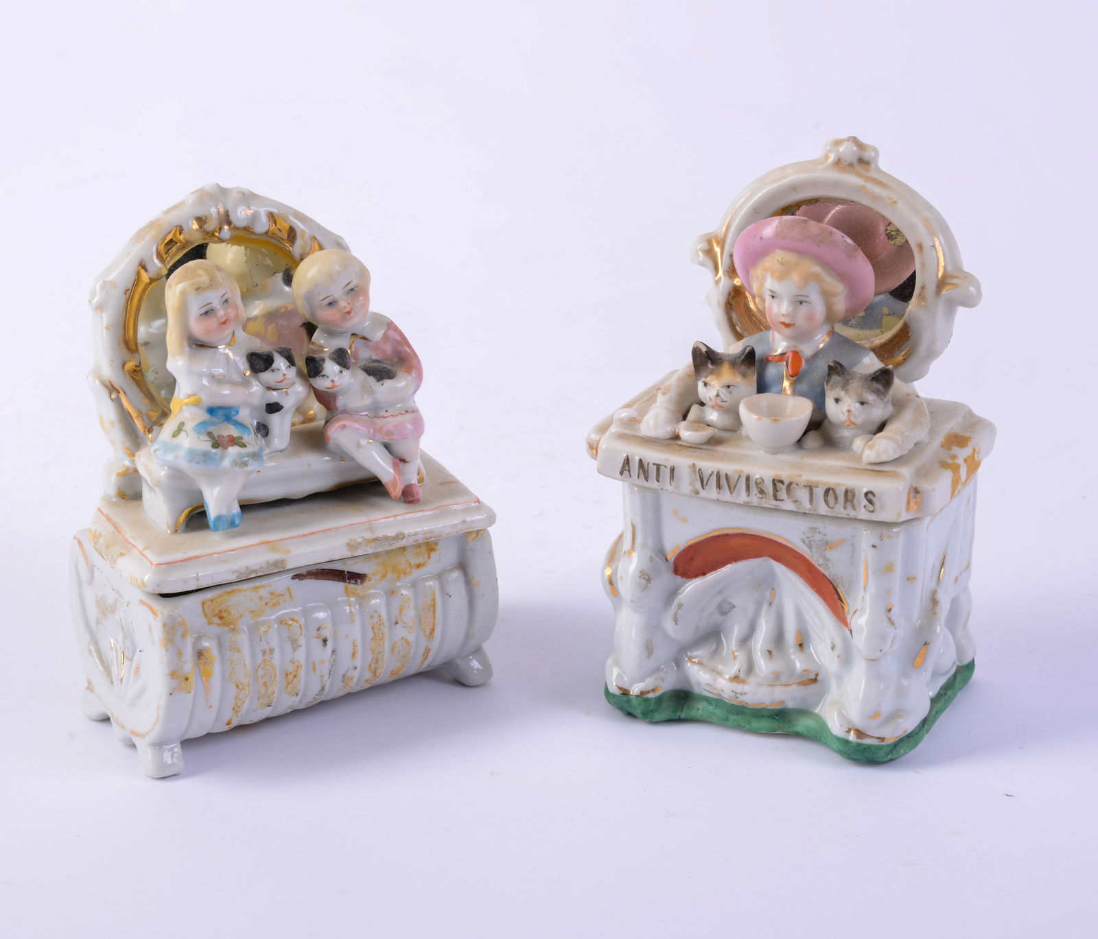 Two Staffordshire Covered Boxes With Children and Cats.: Heights 4 and 4.5 inches. One with hairline crack, both with some surface loss.