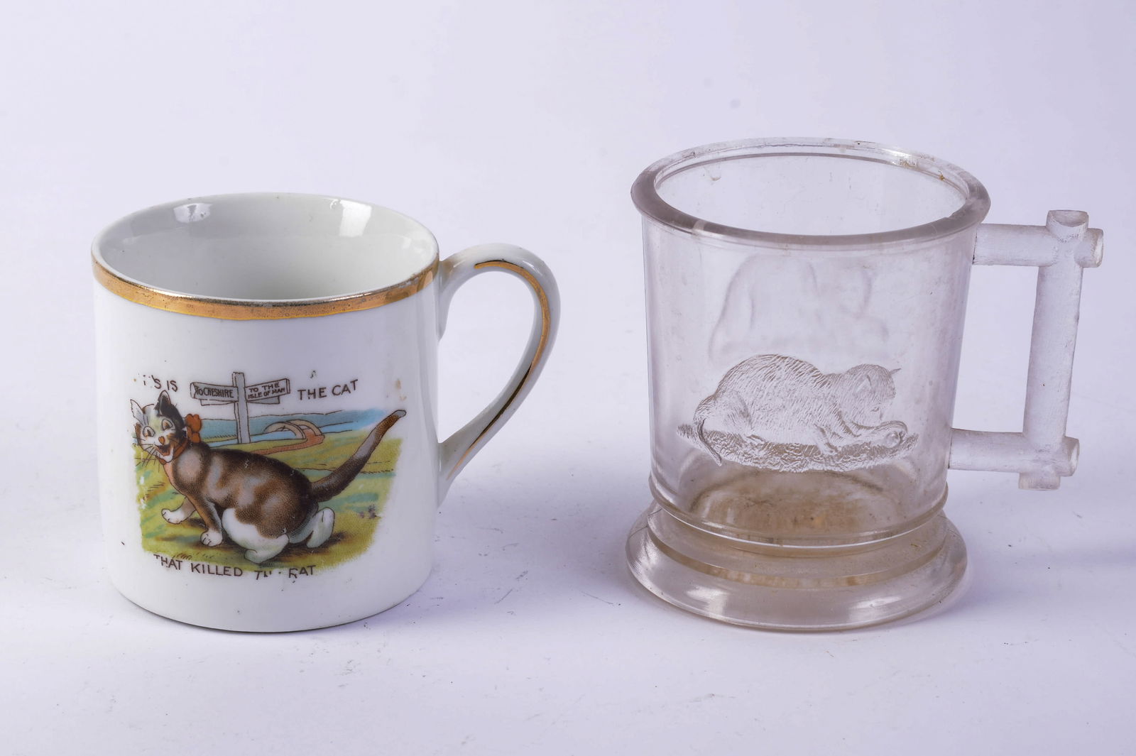 Two Mugs With Cats.: Porcelain, 'This is the Cat that Killed the Rat,' height 3 inches, and a glass example.