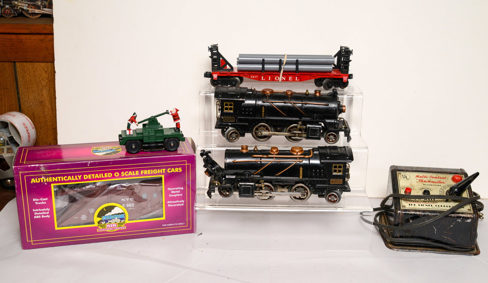 Two Lionel Locomotives, Stake Car, and Other Items.: 262 and 262E, 6477 stake car, Lionel Trainmaster transformer, M.T.H freight car, santa railcar.
