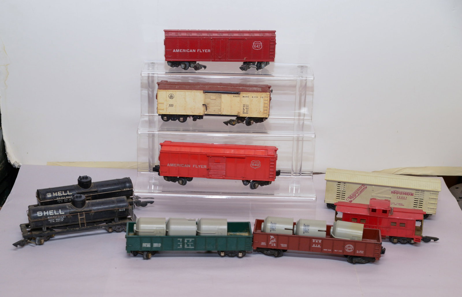 Nine Train Cars.: American Flyer, Shell, and others. Some scratches.
