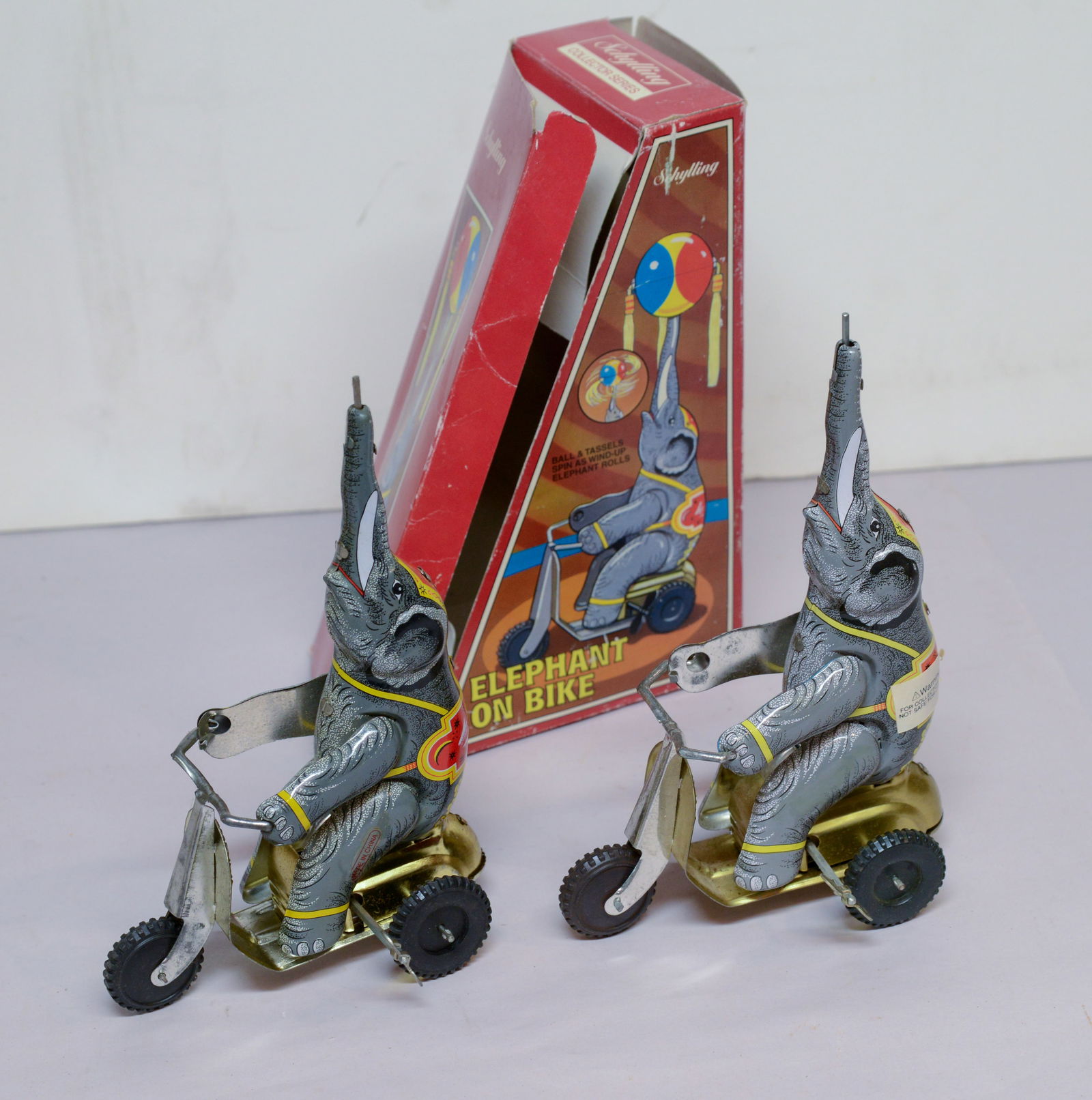 Two Schylling Elephant on Bike Toys.: One with original box, one missing ball.