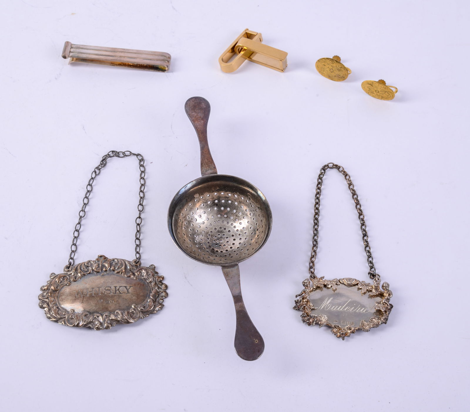 Three Sterling Pieces.: Tea strainer, length 6 inches, and two decanter tags. Total 59 grams.