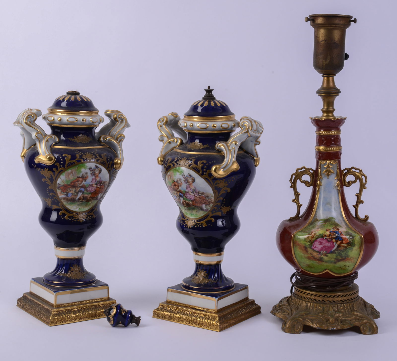 Pair of Sevres Style Porcelain Blue Ground Vases Mounted as Lamps.: With Sevres style red ground vase mounted as a lamp. Height of pair 15 inches. Finial broken off one lamp.