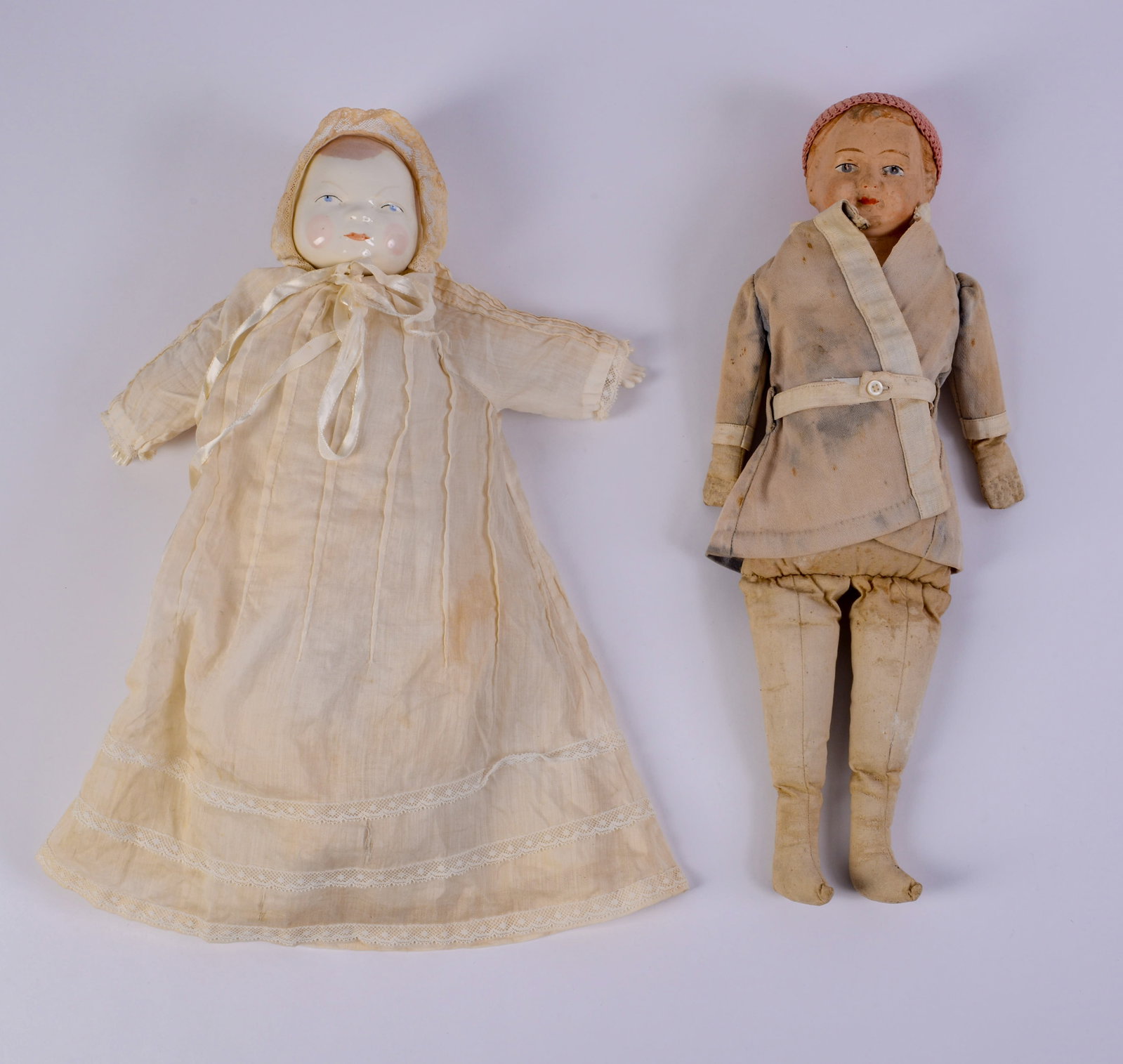 Two Dolls.: One marked 1915, composition material, the other with porcelain head. Heights 14 and 15 inches.