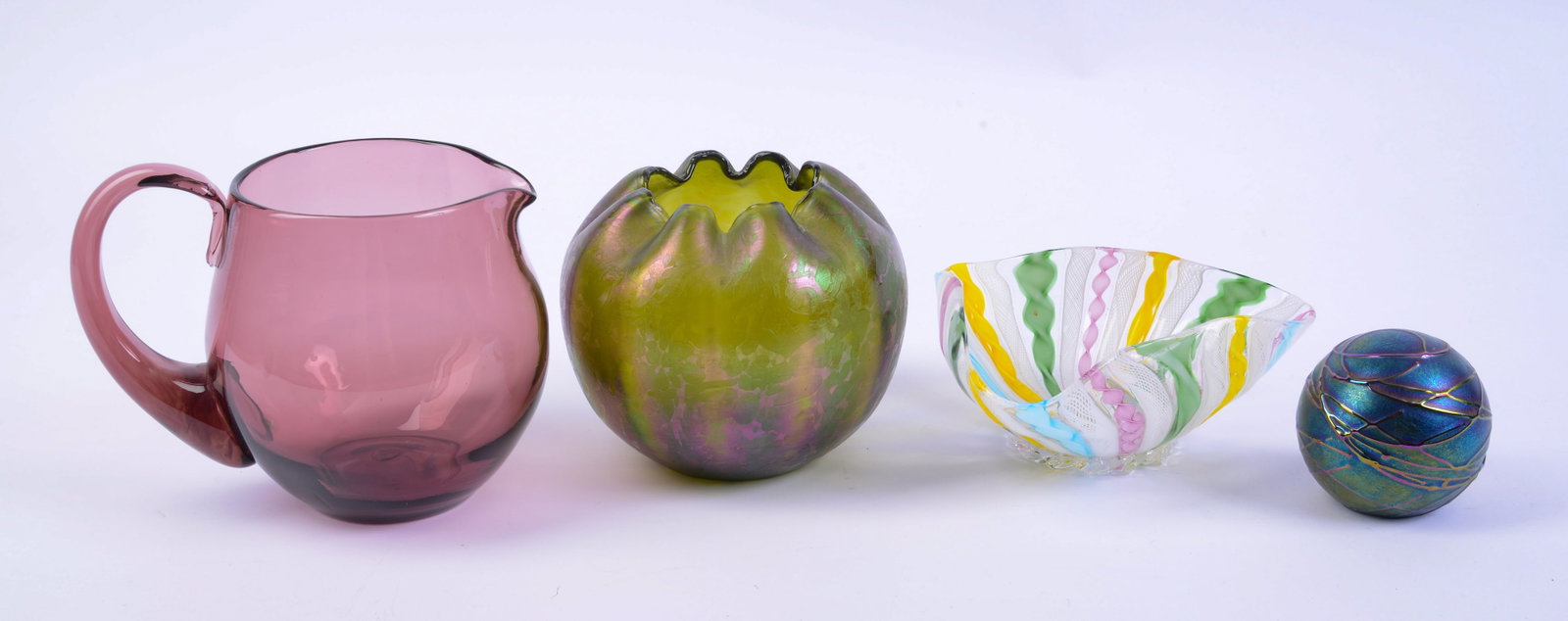Four Art Glass Pieces.: Paperweight, marked The Glass Eye, 1989, diameter 3.25 inches. Murano bowl, small chip at rim. Amethyst pitcher, height 5.5 inches, and an iridescent vase.