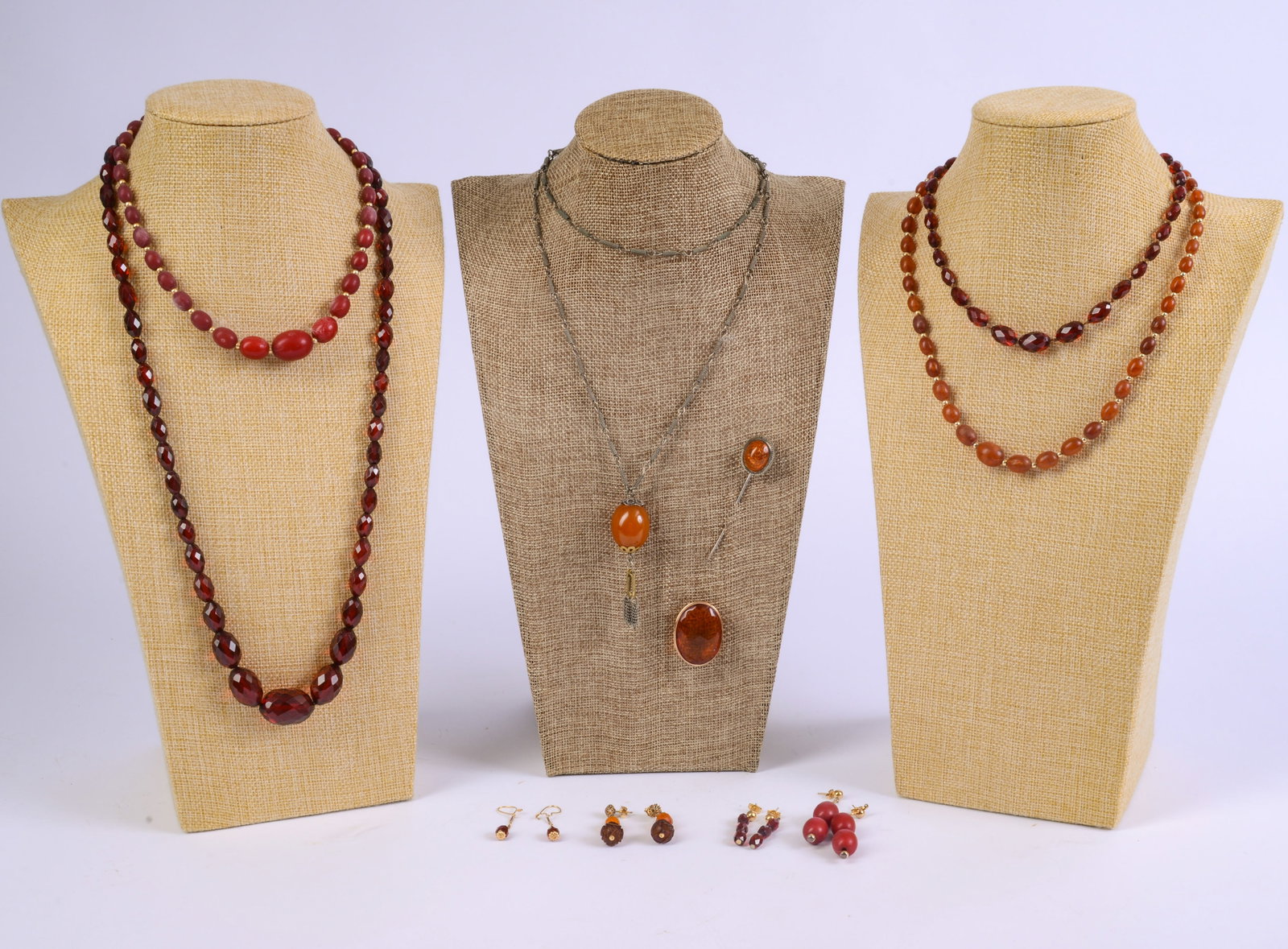 Group of Amber and Red Beaded Jewelry.: 4 necklaces, longest 24 inches, hat pin, and 2 pairs of earrings.