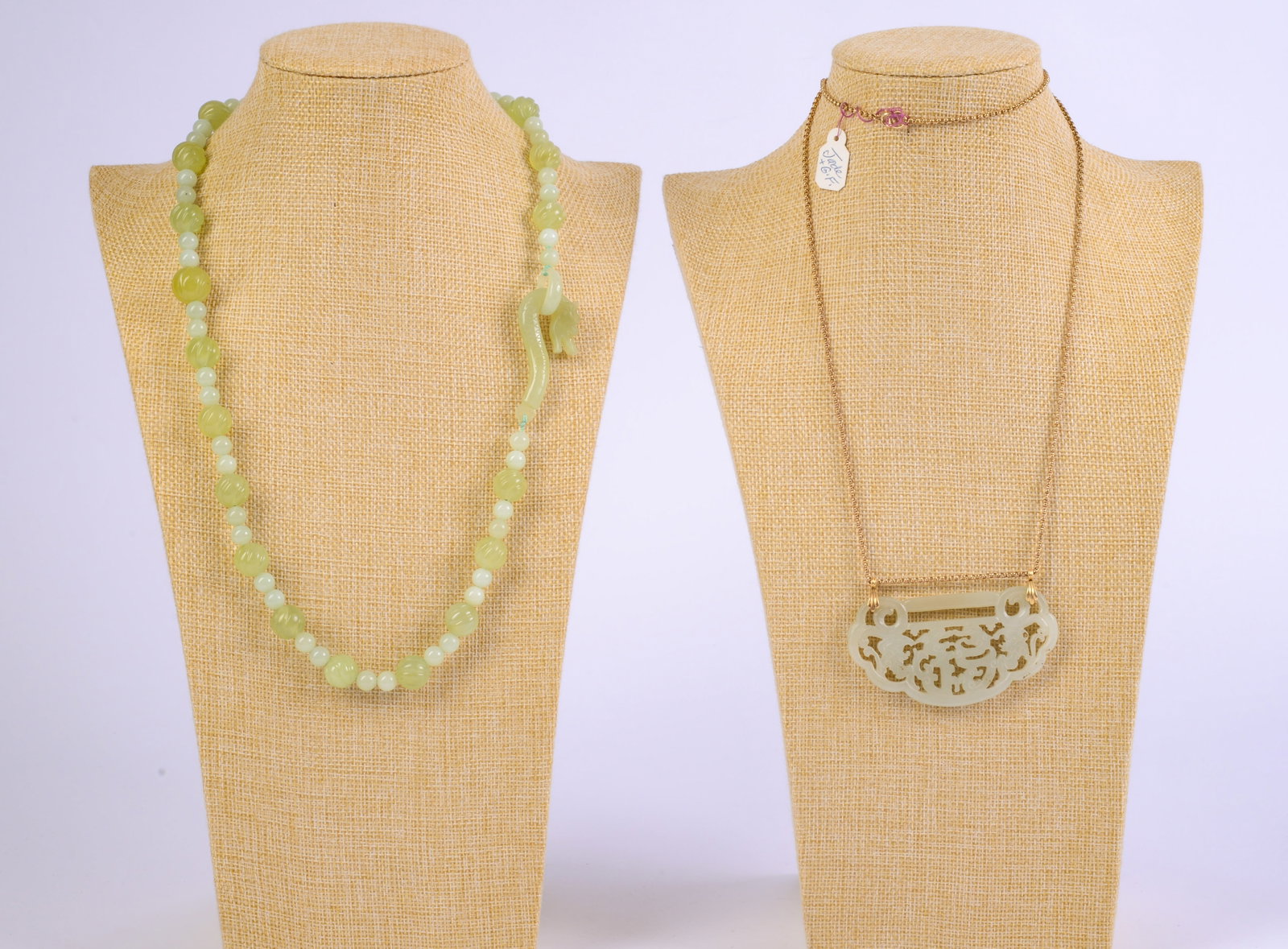 Two Jade Necklaces.: One with pendant, 3 x 1.5 inches, the other with dragon clasp, length 24 inches.