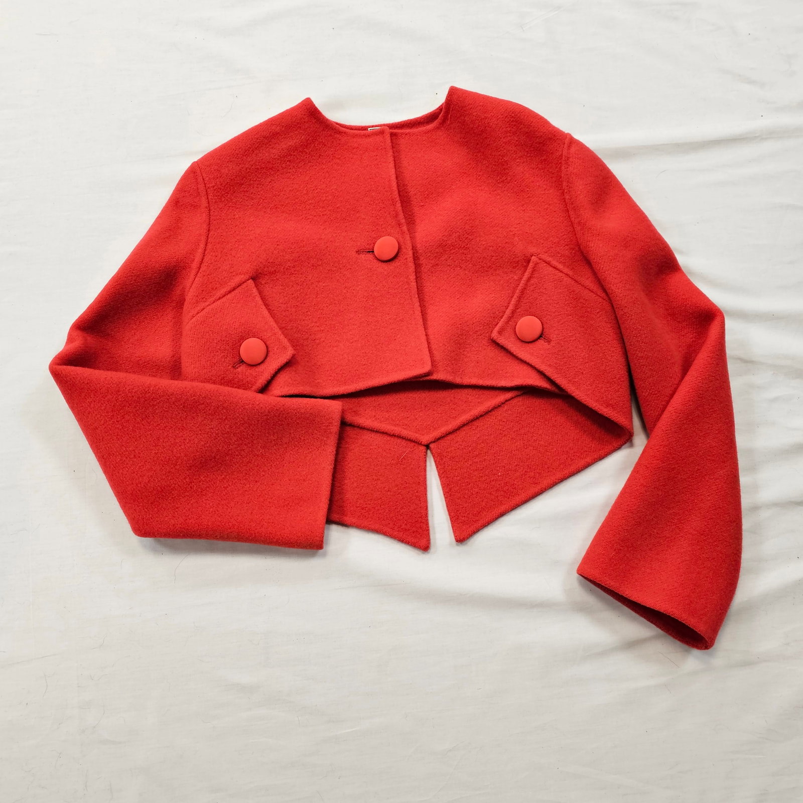 Geoffrey Beene Red Wool Bolero: Vintage Geoffrey Beene red wool, single button, bolero with faux button pockets, and a vented tail back.