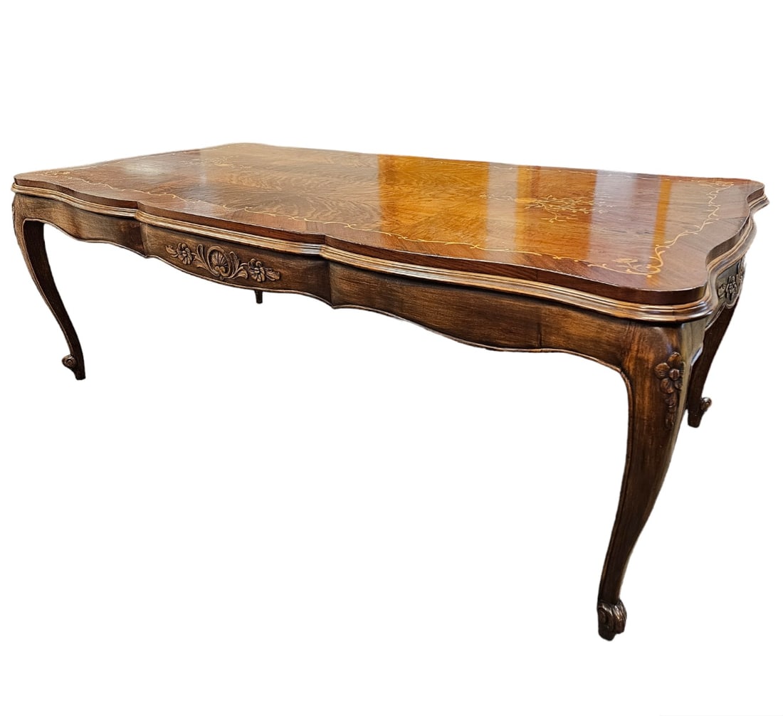 Rococo Style Dining Table: The serpentine top with stepped edge decorated with scrolling floral vines raised on cabriole legs. 32in. (81cm) h. 86in. (218cm) l. 42in. (107cm.) d