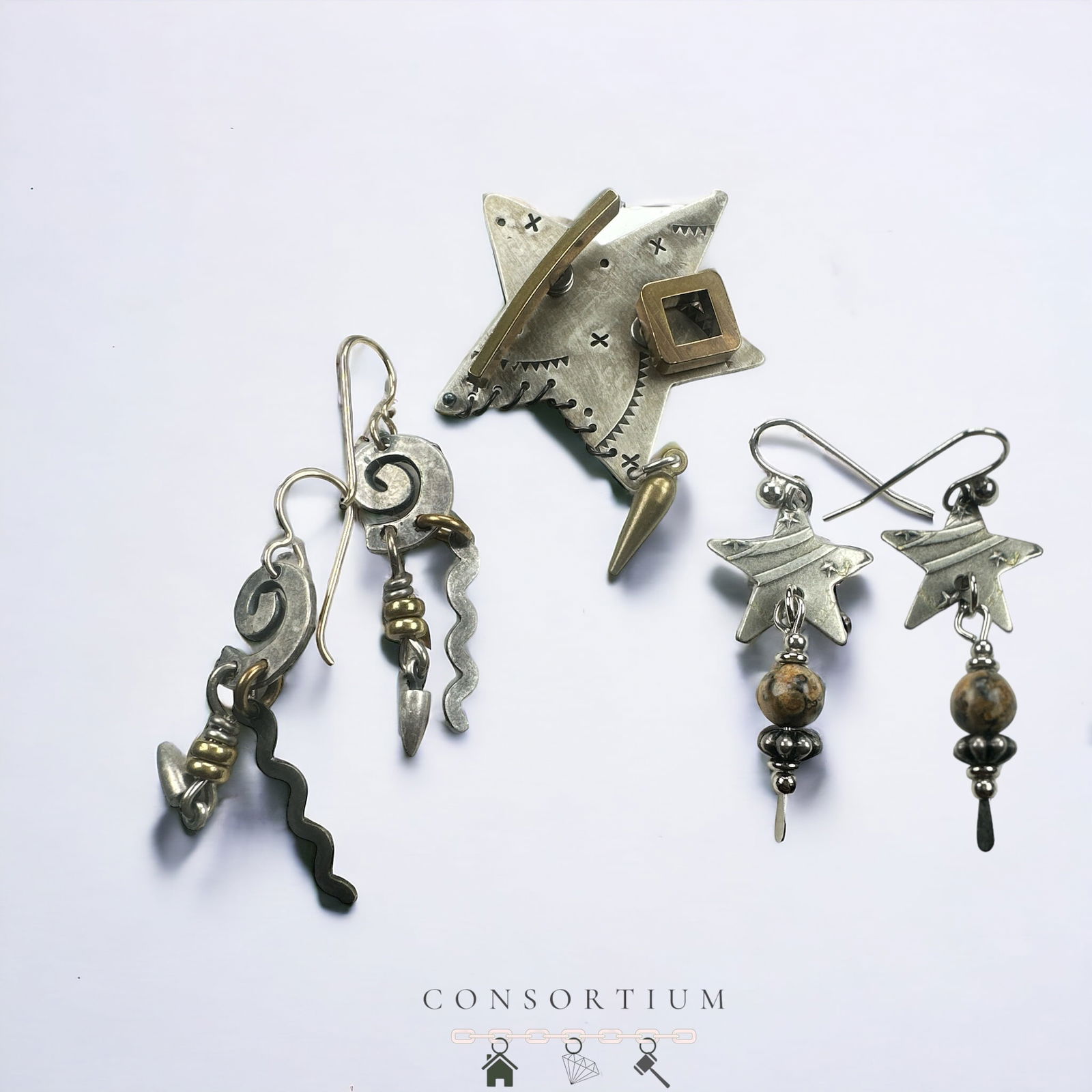 Thomas Mann Mixed Metals Jewelry Suite: Including a sterling silver, mixed metals pin designed as a star measuring approximately 1.60 x 1.40 inches; a pair of spiral drop earrings measuring approximately 1.75 inches in length, together