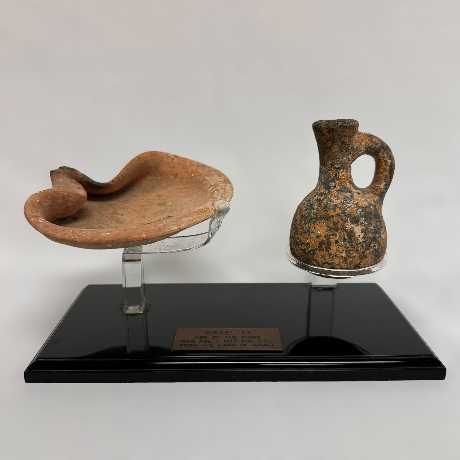 Israelite Lantern and Oil Pitcher: Israelite pottery lantern and oil pitcher on display stand with paperwork.
