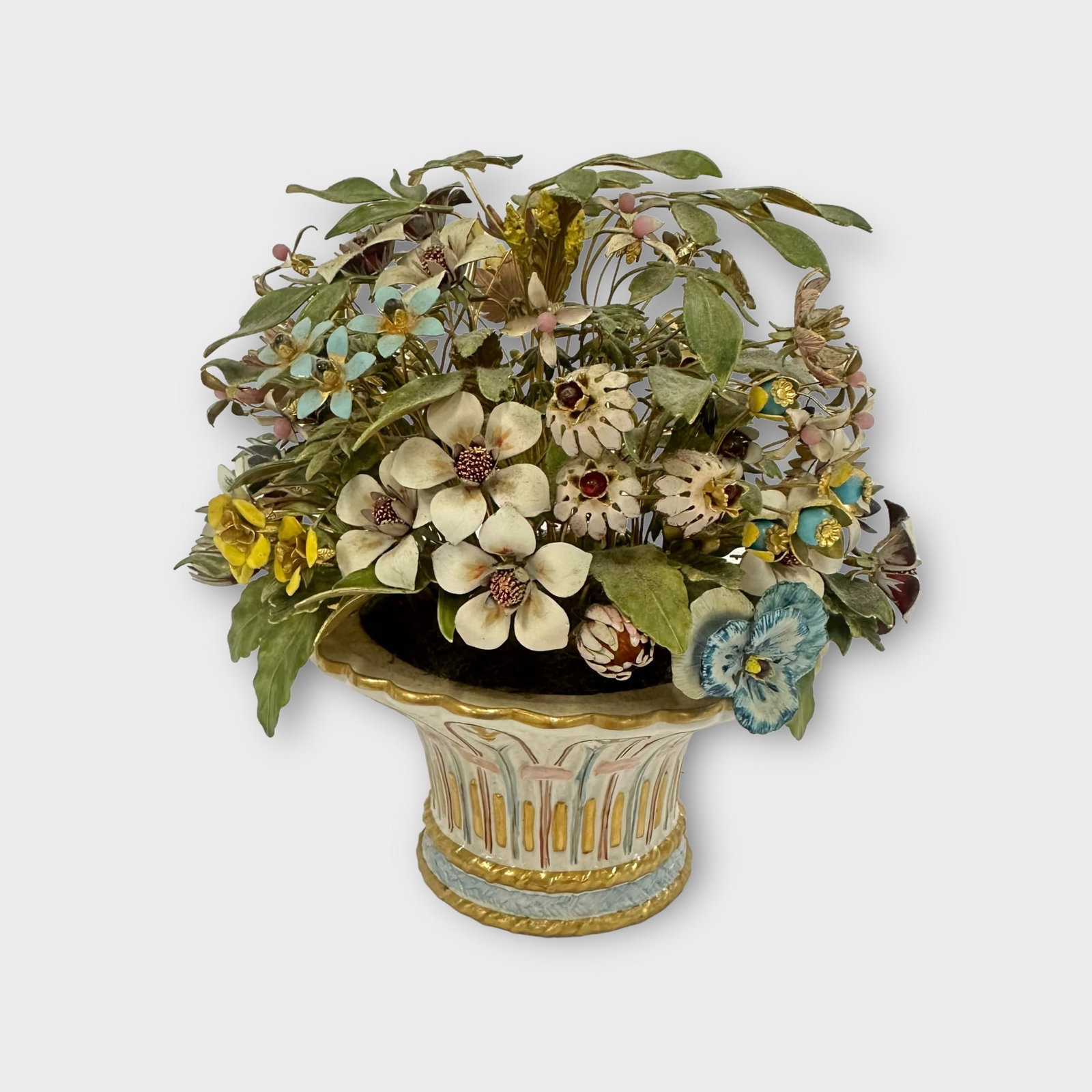 Enamel Flowers in Flowerpot: Enamel flower arrangement in ornate porcelain pot. Each flower and leaf is very detailed, some with glass beads. Measures approximately 8 in tall with an 8 in diameter. Condition is good.