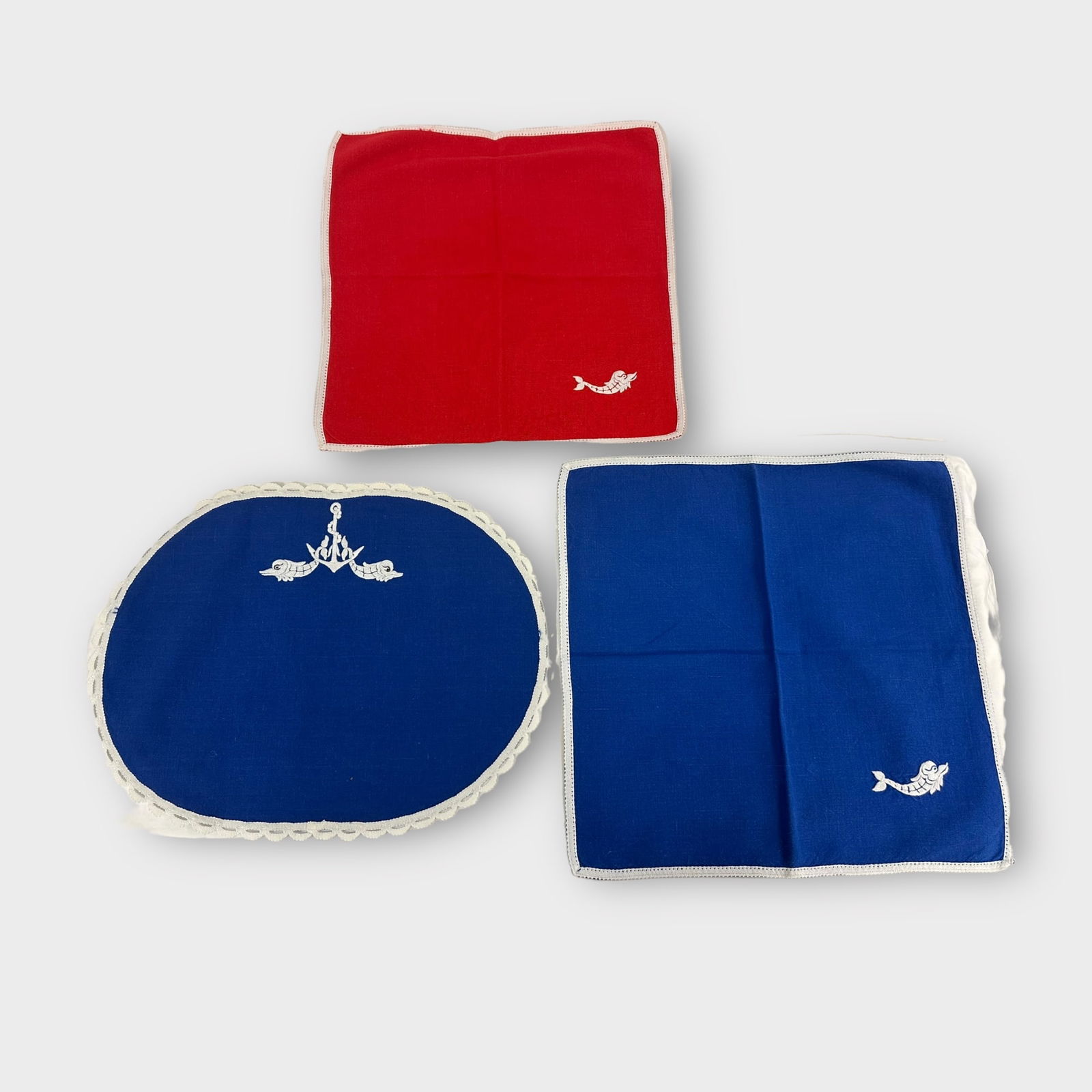 Group of Table Linens: Group of table linens in red and blue, the napkins and mats edged with lace border. Condition is good, very little staining.