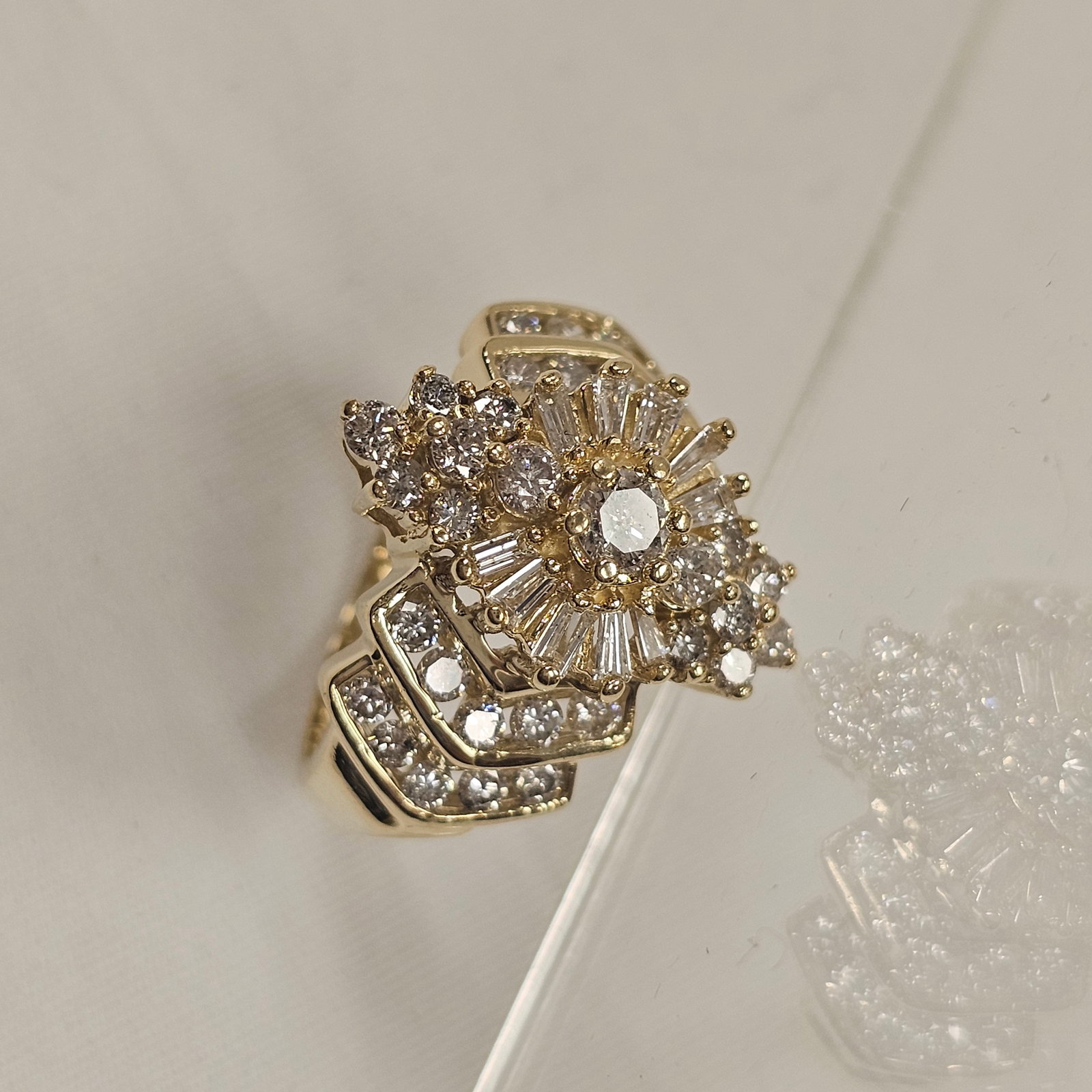 Diamond, 14k Yellow Gold Ballerina Ring: Featuring thirty-five round brilliant-cut and ten baguette-cut diamonds weighing a total of approximately 1.48 cttw., set in a 14k yellow gold ring mounting, size 5 1/2. Gross weight: 7.5 grams.