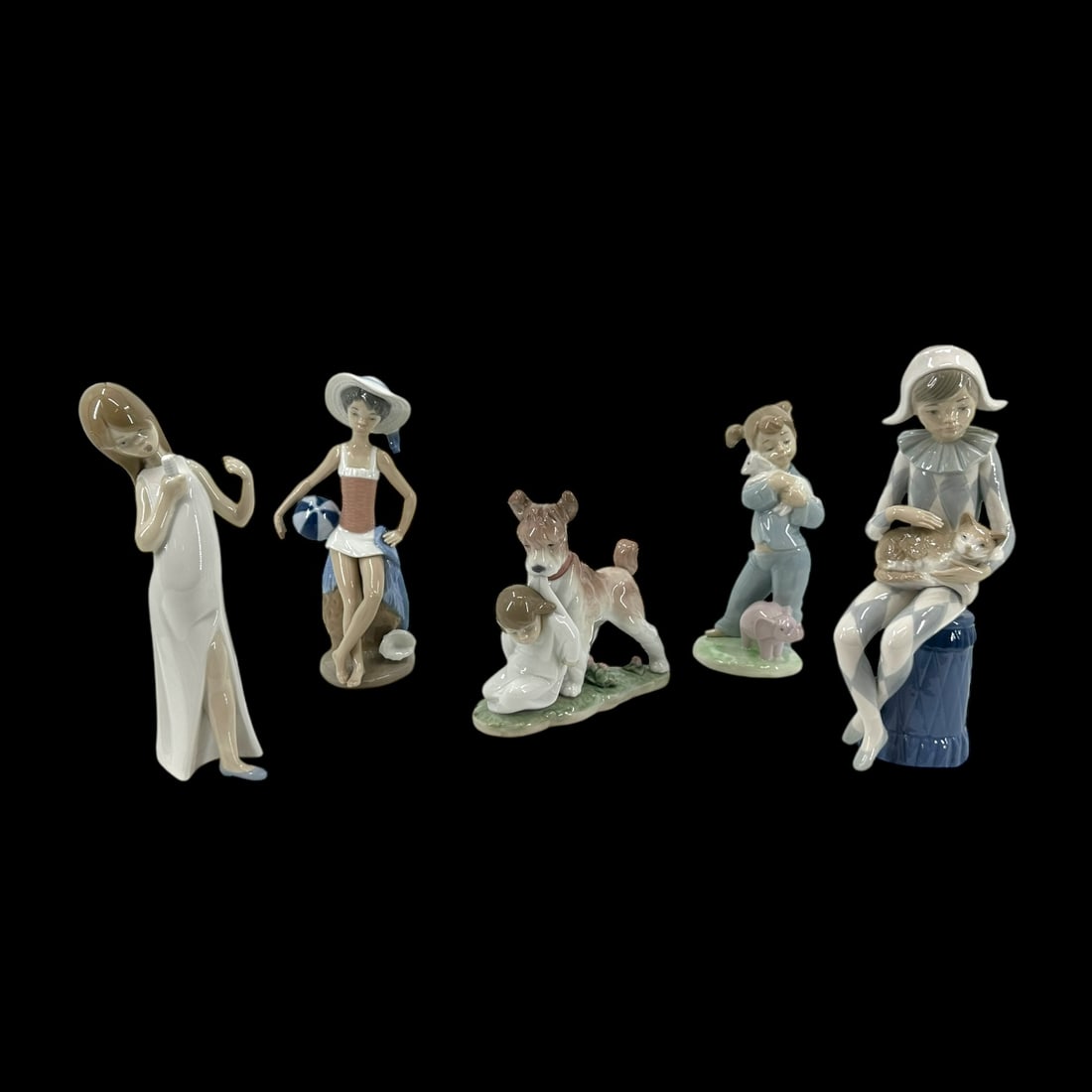 Group of 5 Lladro Spanish Porcelain Children Themed Figurines: Group of 5 Lladro Spanish porcelain children themed figurines, a beach bather 5219, 8 in H; singer, 7 3/4 in H; circa 1986 Nao Edition seated Jester or Harlequin with cat, 9 1/4 in H; together with (2