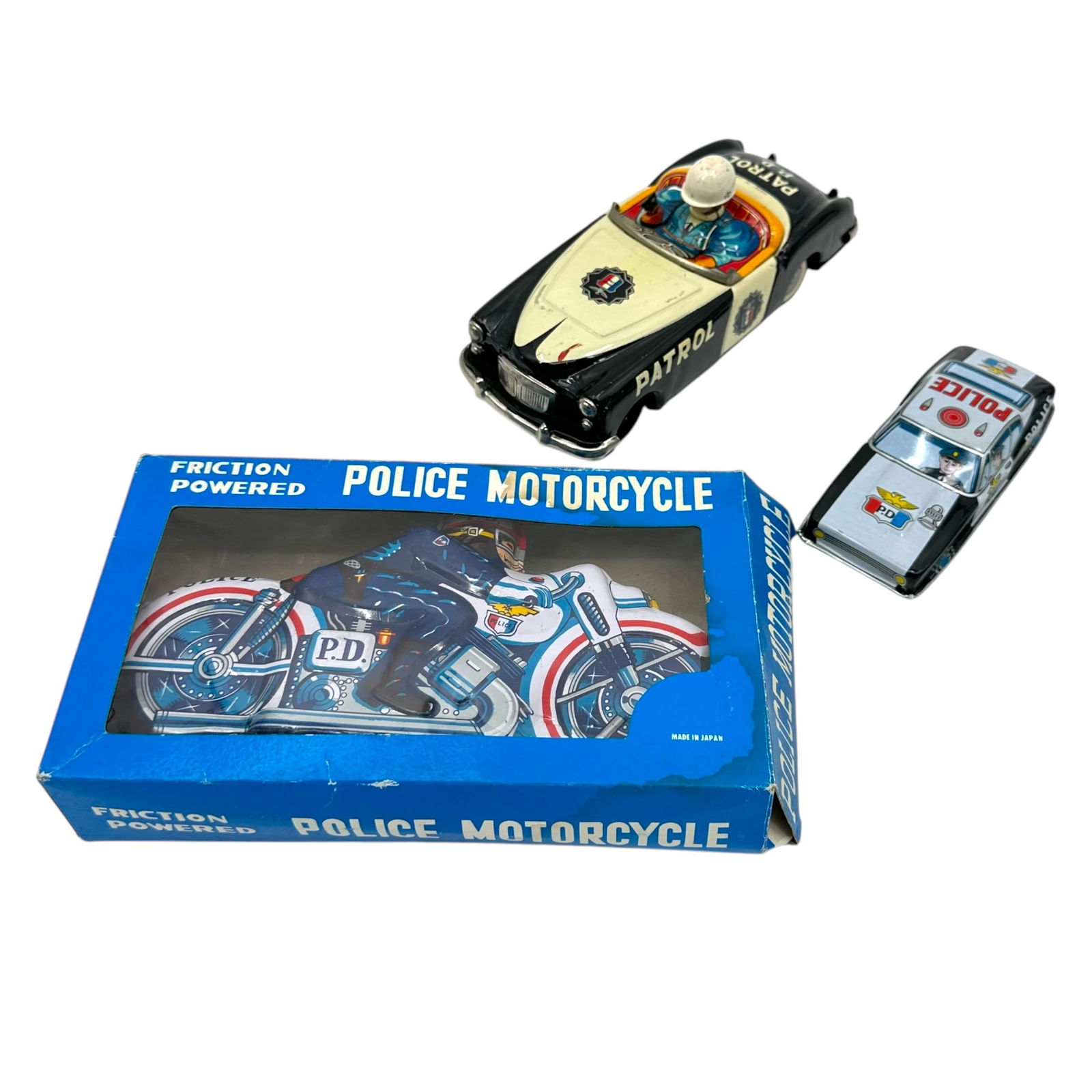 (Lot of 3) Vintage Japanese Made Police Tin Toys: (Lot of 3) vintage Japanese police tin toys including a friction powered police motorcycle in box, a highway patrol car and a police car, largest measuring 8 1/2 in L. All purchases are as is, the abs