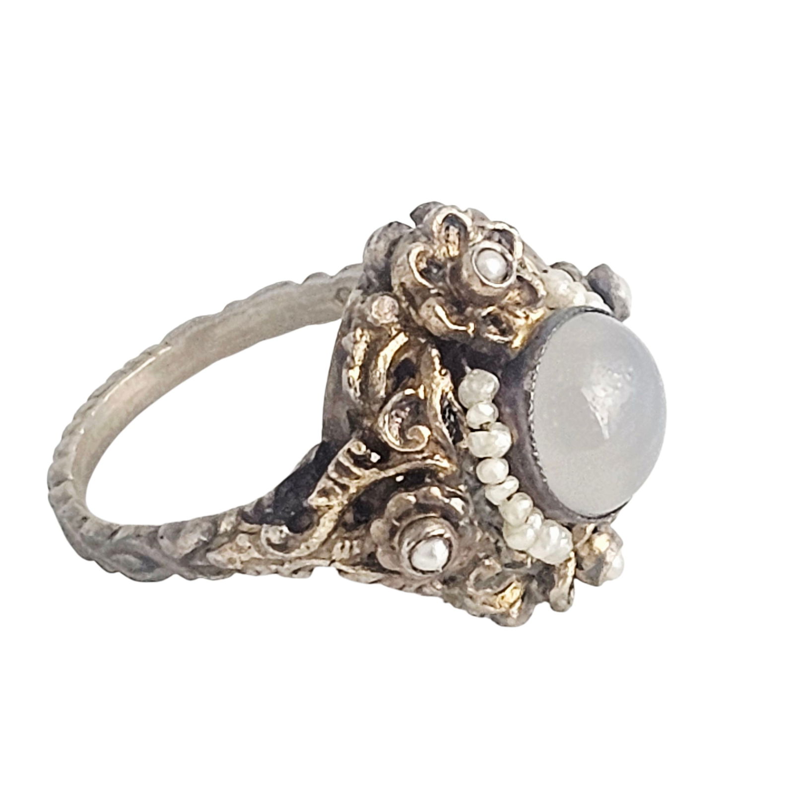 Austro-Hungarian Chalcedony, Pearl, Silver Gilt Ring: Featuring a round chalcedony cabochon accented by seed pearls, set in a repousse, silver gilt ring mounting, size 8 1/4. Gross weight: 6.8 grams. Lots are sold as-is. Please inquire for any additional