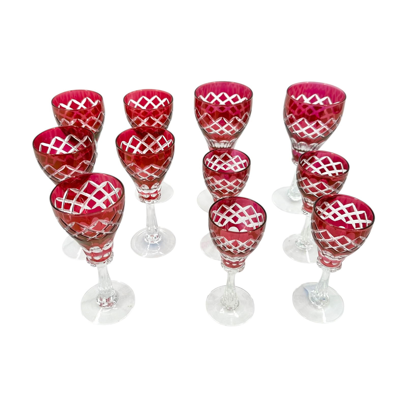 (Lot of) 11 Cranberry Cut to Clear Glasses: (Lot of) 11 cranberry cut to clear glasses, including wine, sherry, and aperitif glasses. Cut in a crisscross pattern with a clear stem. Condition is good, with slight fading on the cranberry col