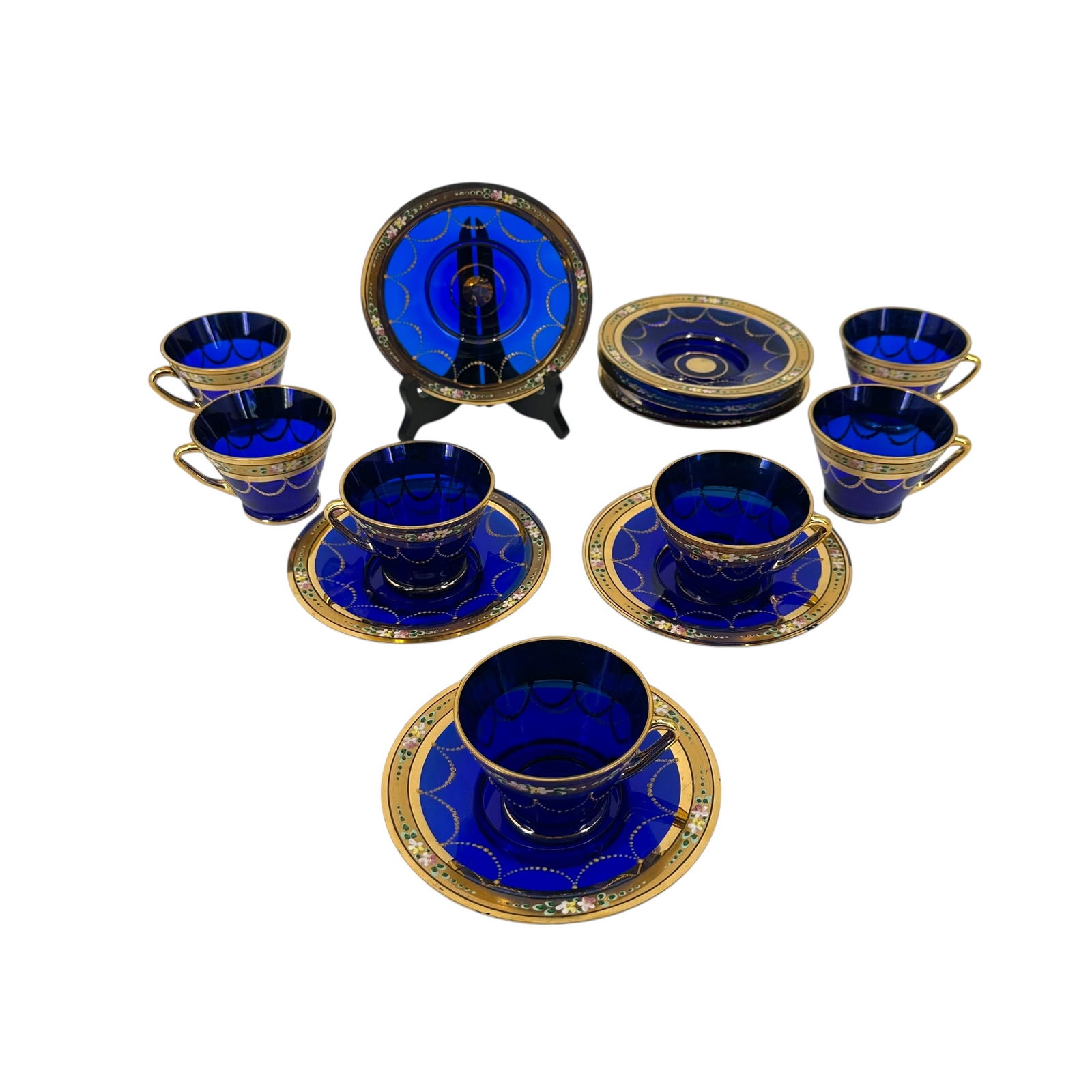 (Lot of) 7 Bohemian Czech Cobalt Blue Glass Teacup and Saucer Set: (Lot of) 7 Bohemian Czech cobalt blue glass teacup and saucer sets featuring gilt floral accents on both the cups and saucers. Condition: one cup has a minor chip.