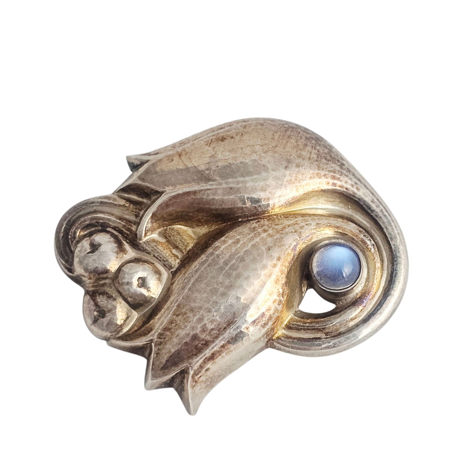 Moonstone, Silver Tulip Pin, 100 C, Georg Jensen: Designed as two intertwined tulips, highlighted by one round moonstone cabochon, set in a sterling silver pin mounting measuring approximately 1.80 x 1.40 inches. Marked: Georg Jensen within beaded ov
